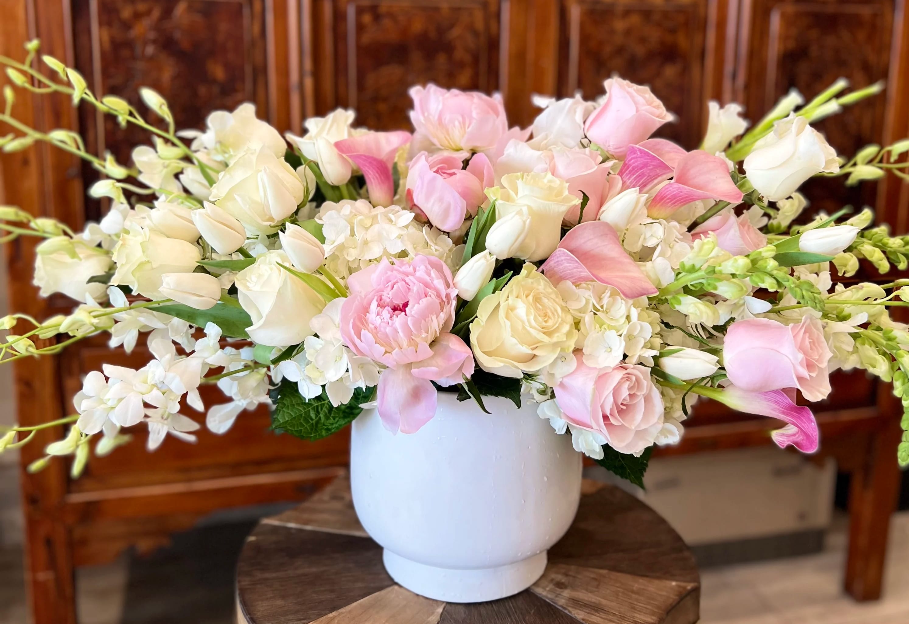 Pink and white floral arrangement in a white vase