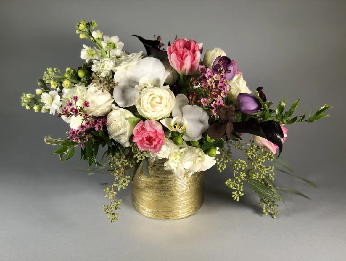 Mixed bouquet in a gold vase with pink, white, and purple flowers