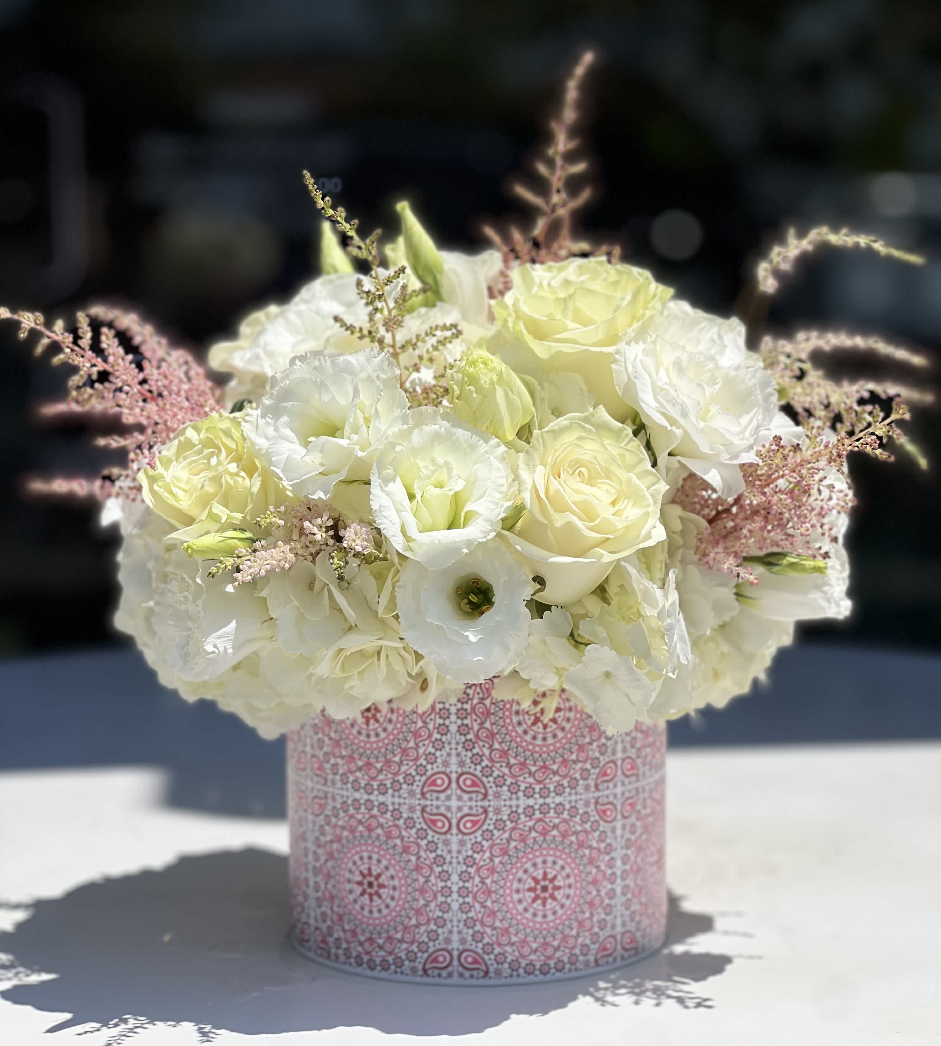 White and pale yellow bouquet in a pink patterned box