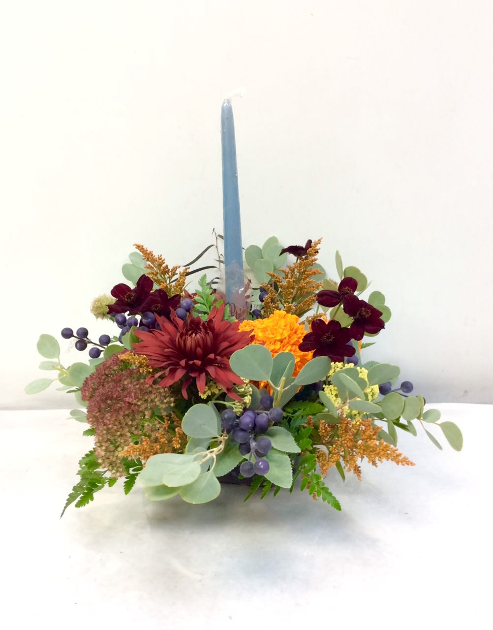 Fall Flame - The perfect small centerpiece for a side table or intimate gathering.  A single candle sheds a light on beautiful autumnal texture and colors.  This design is perfect for a table of 4 to 6 persons and can be modified to meet your size gathering.  Also pictured as a round design but can be an oval shape if needed.