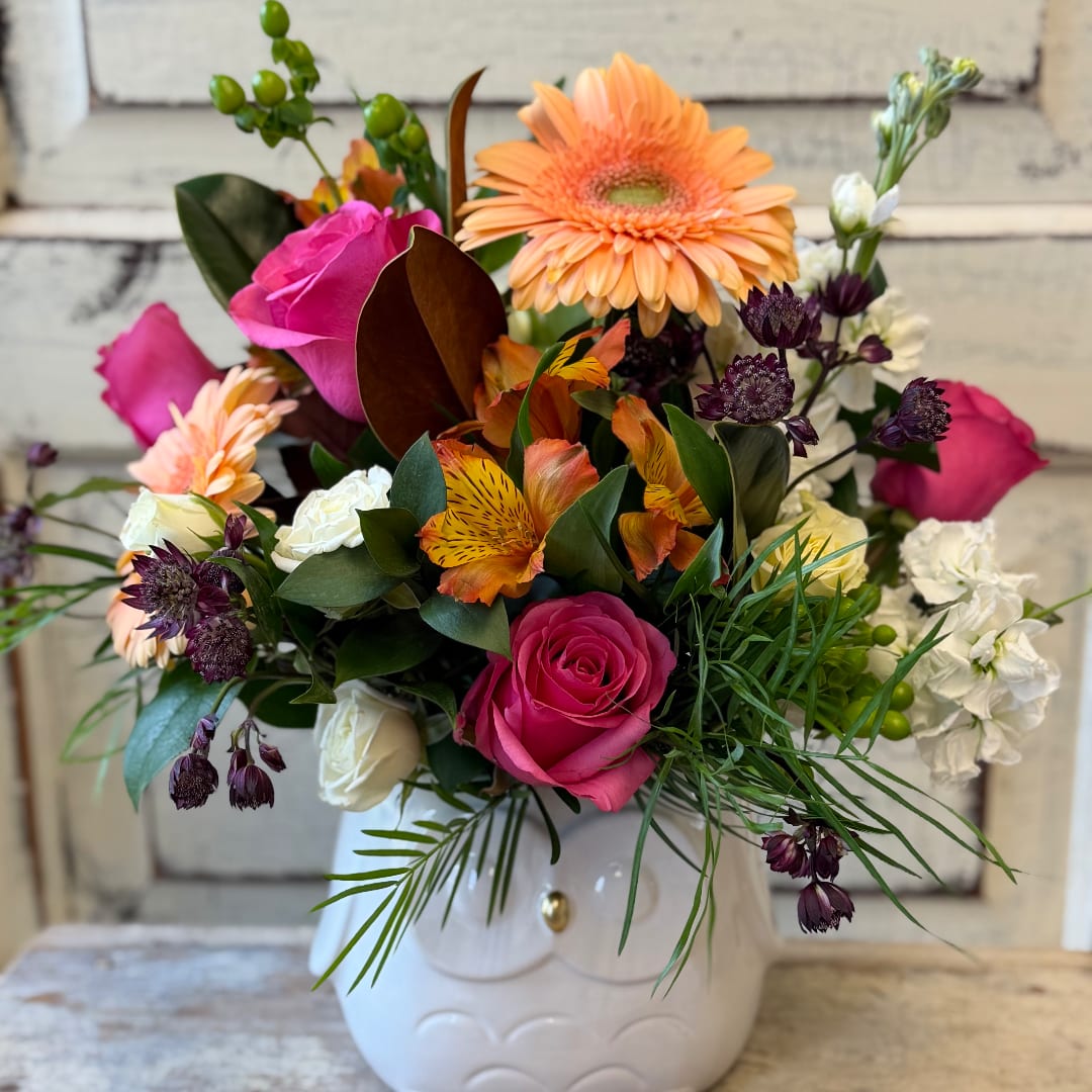 Mixed bouquet in a white ceramic vase with pink roses and peach gerberas