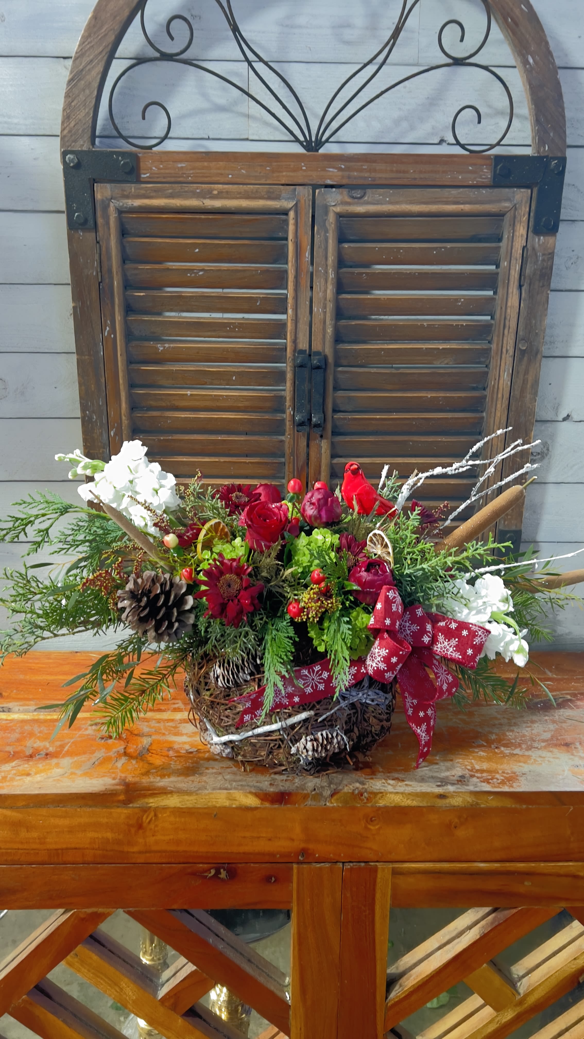Holiday floral arrangement with red and white flowers in a basket