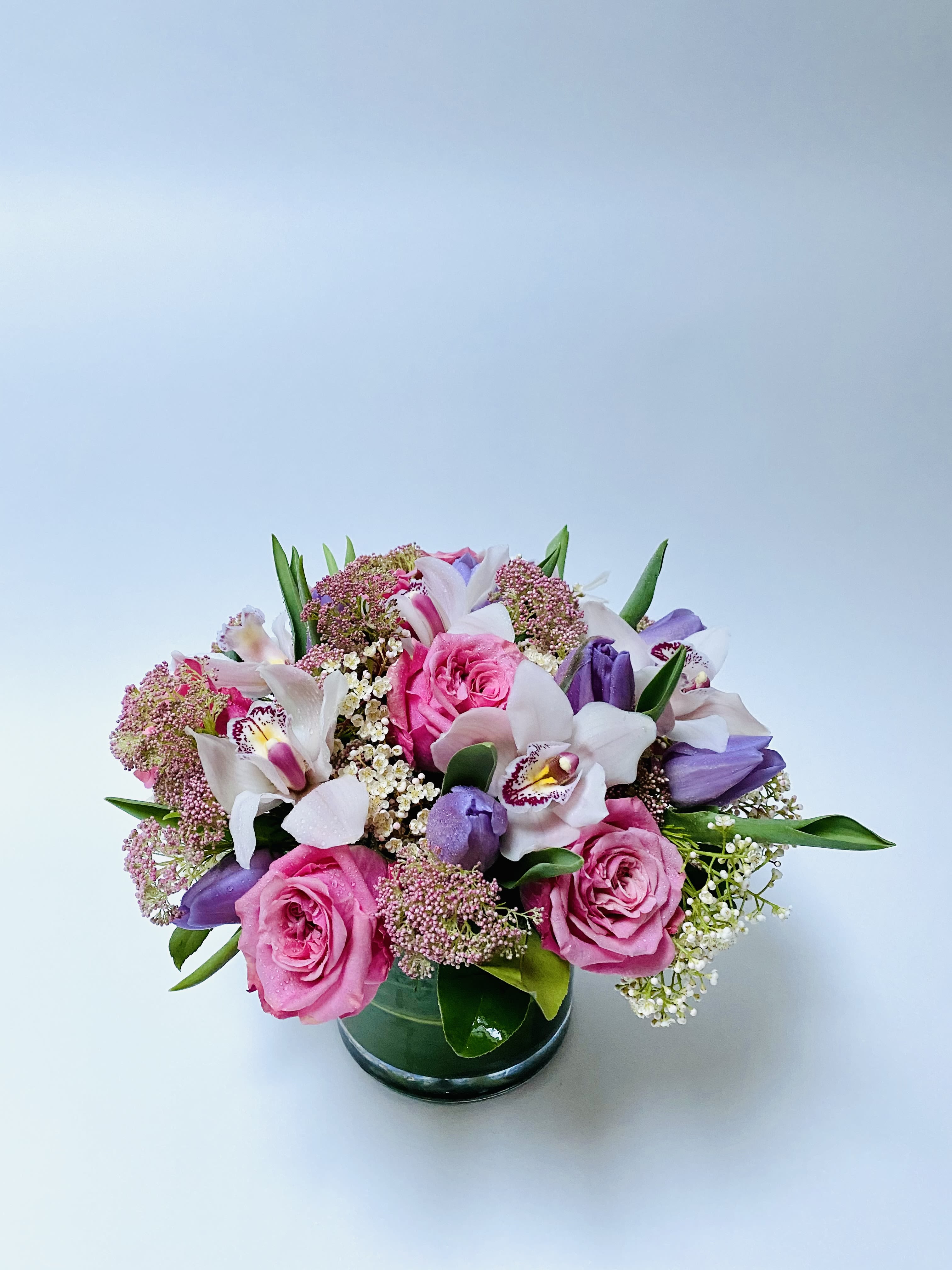 Pink Velvet Harmony - A harmonious blend of soft pinks, lavender hues, and fresh greenery arranged in a natural garden style.   The composition feels lively yet refined, with each element contributing to a balanced and elegant design.