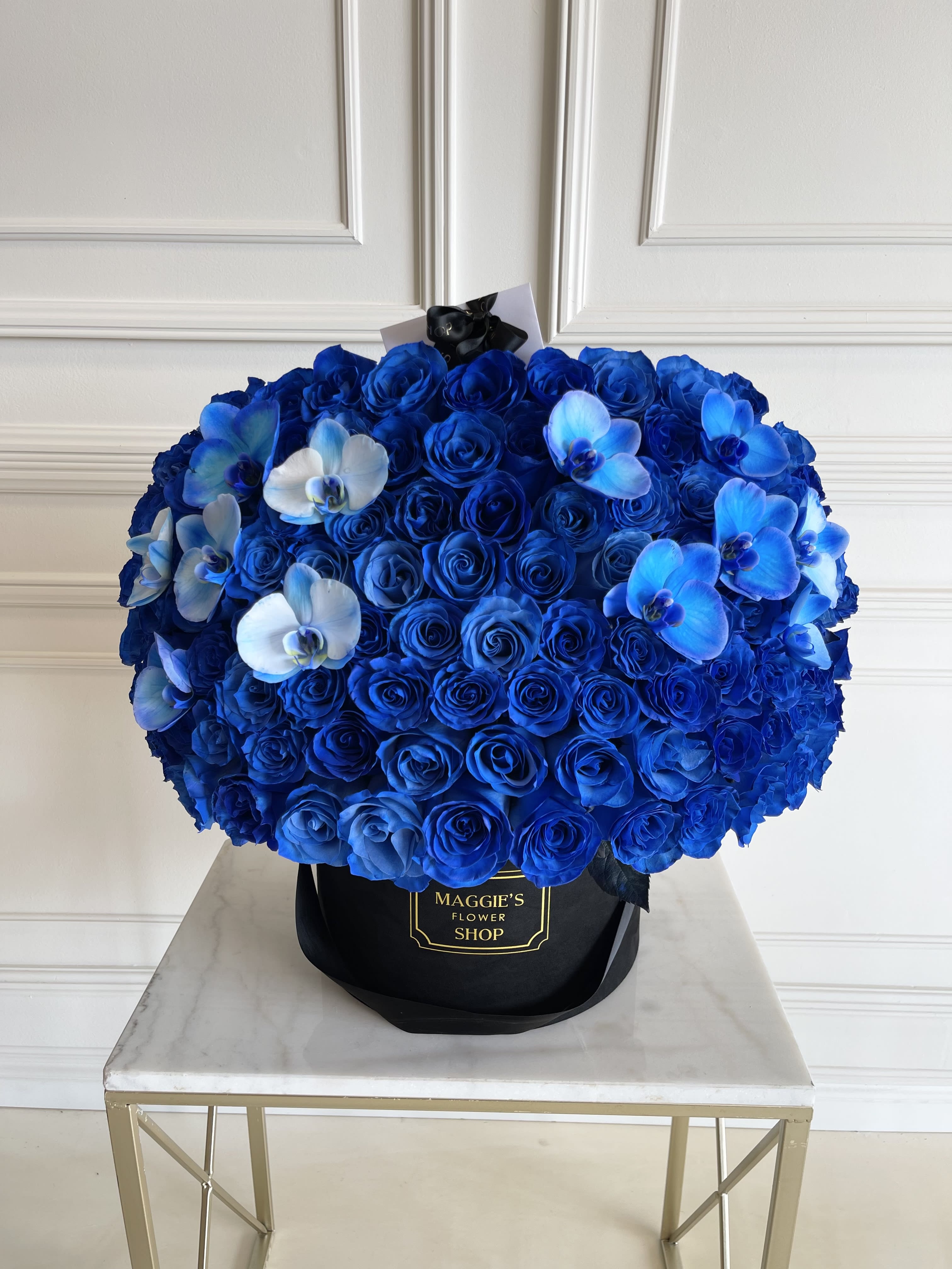 Blue rose bouquet with white and blue orchids in a black hat box