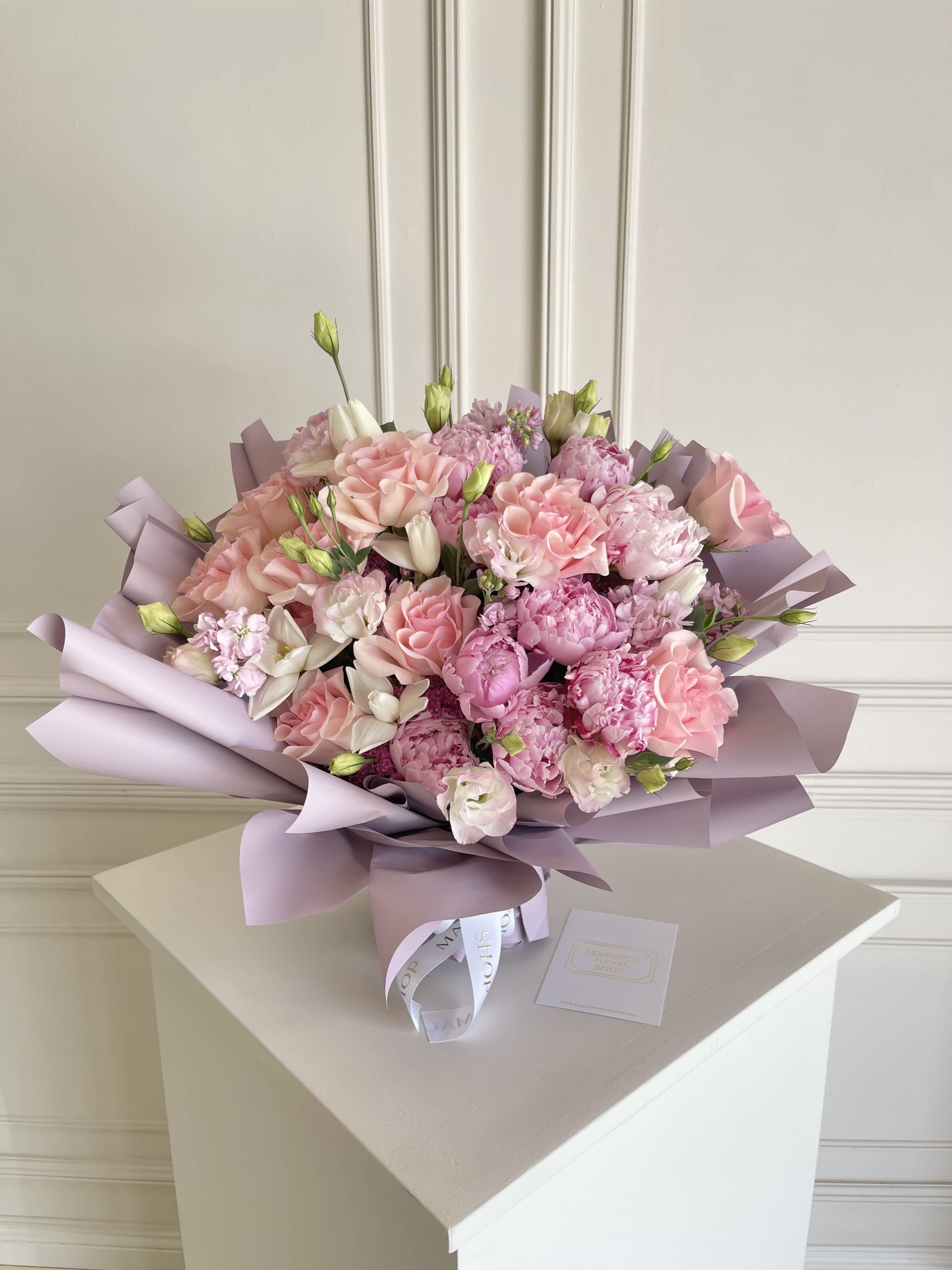 Pink bouquet with roses and carnations wrapped in lavender paper