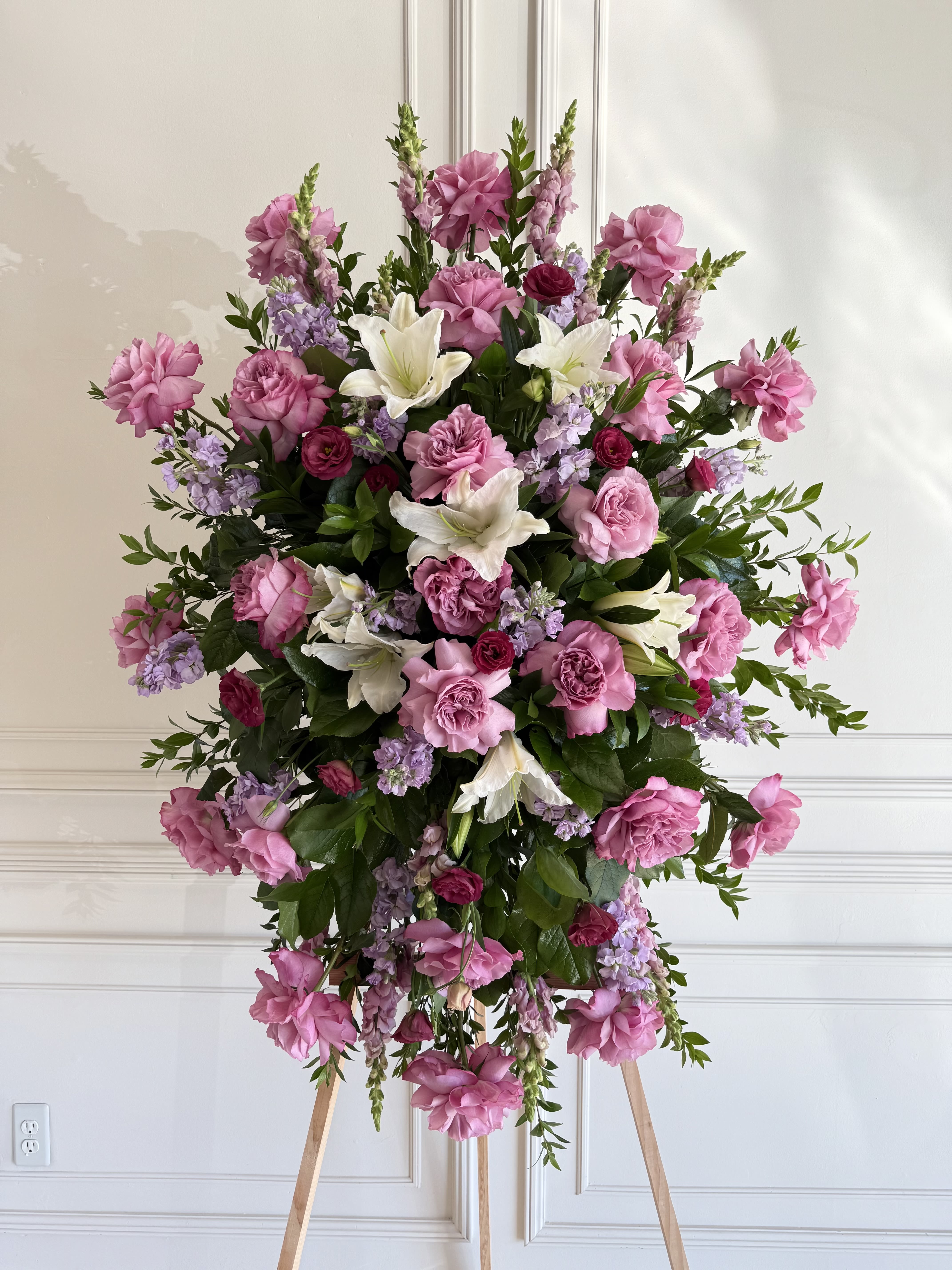 Large pink and white floral standing spray on an easel