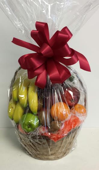 Basket of assorted fruit wrapped in cellophane with a red bow