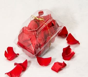 Clear gift box filled with red rose petals and tied with a gold ribbon