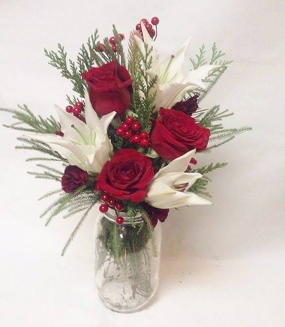 Premium Holiday mason jar - Premium red roses, Oriental lillies and festive decor in a mason jar filled with seasonal greens.