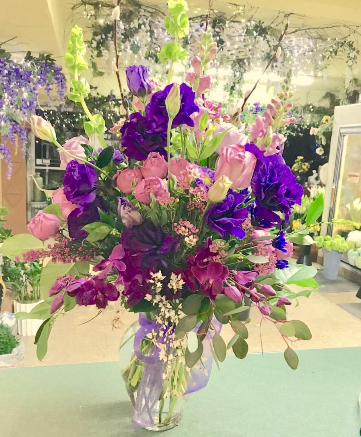Tall bouquet of pink and purple flowers in a clear vase