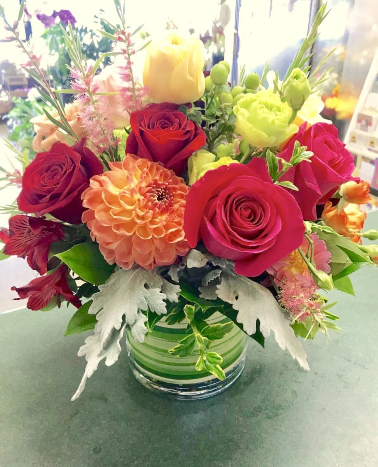 Mixed bouquet of roses and dahlias in a glass vase