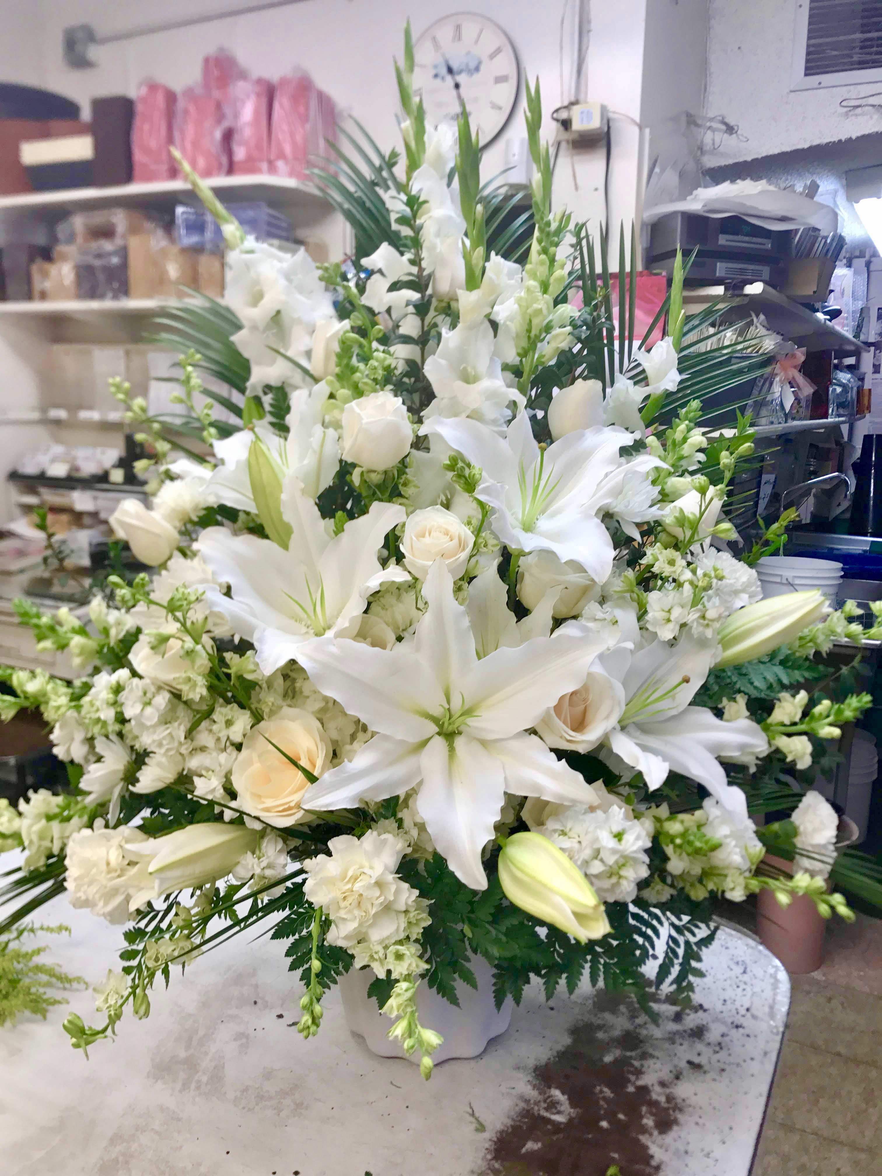 White lilies and roses in a white vase arrangement