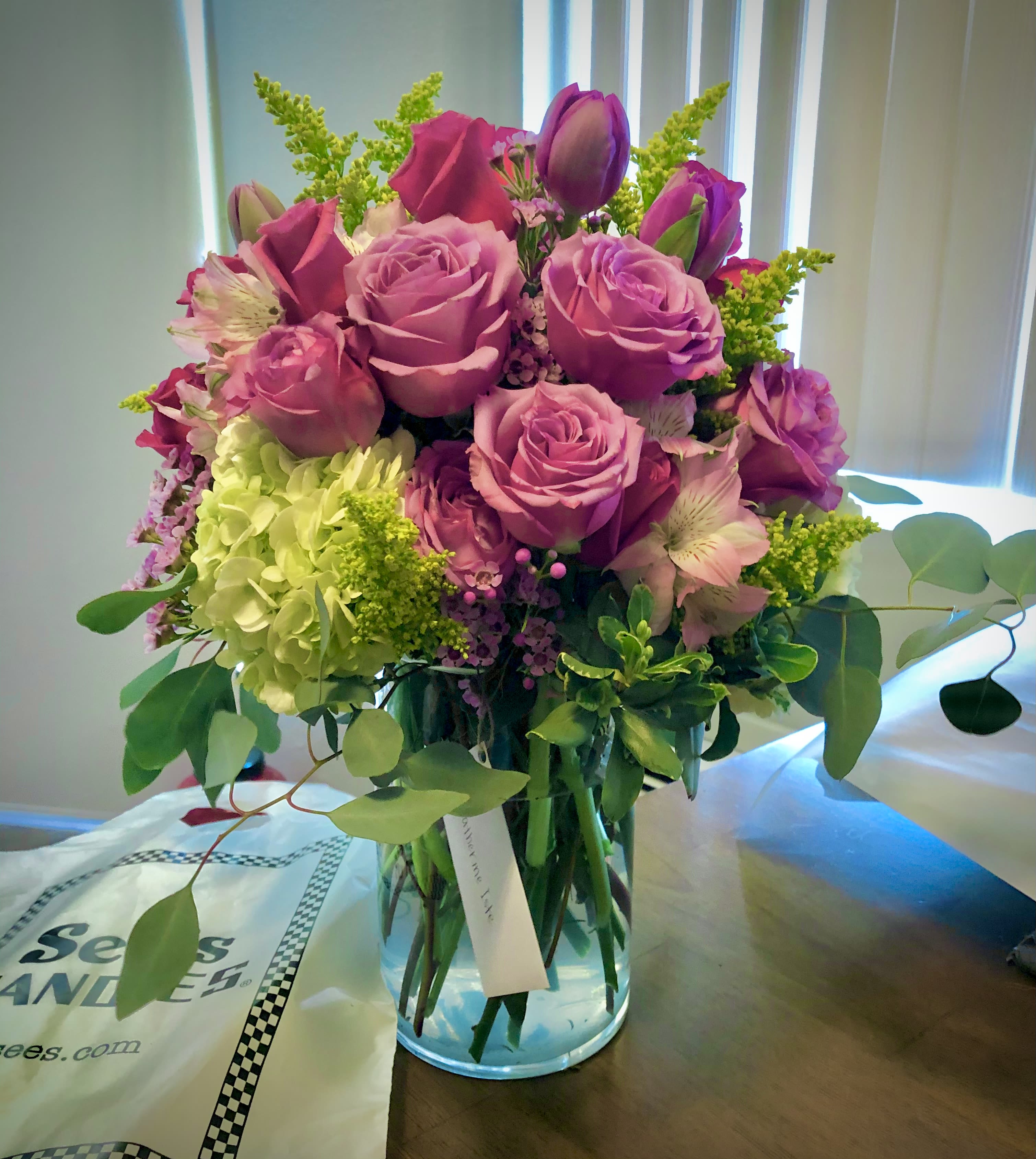 Pink roses and hydrangea in a clear glass vase