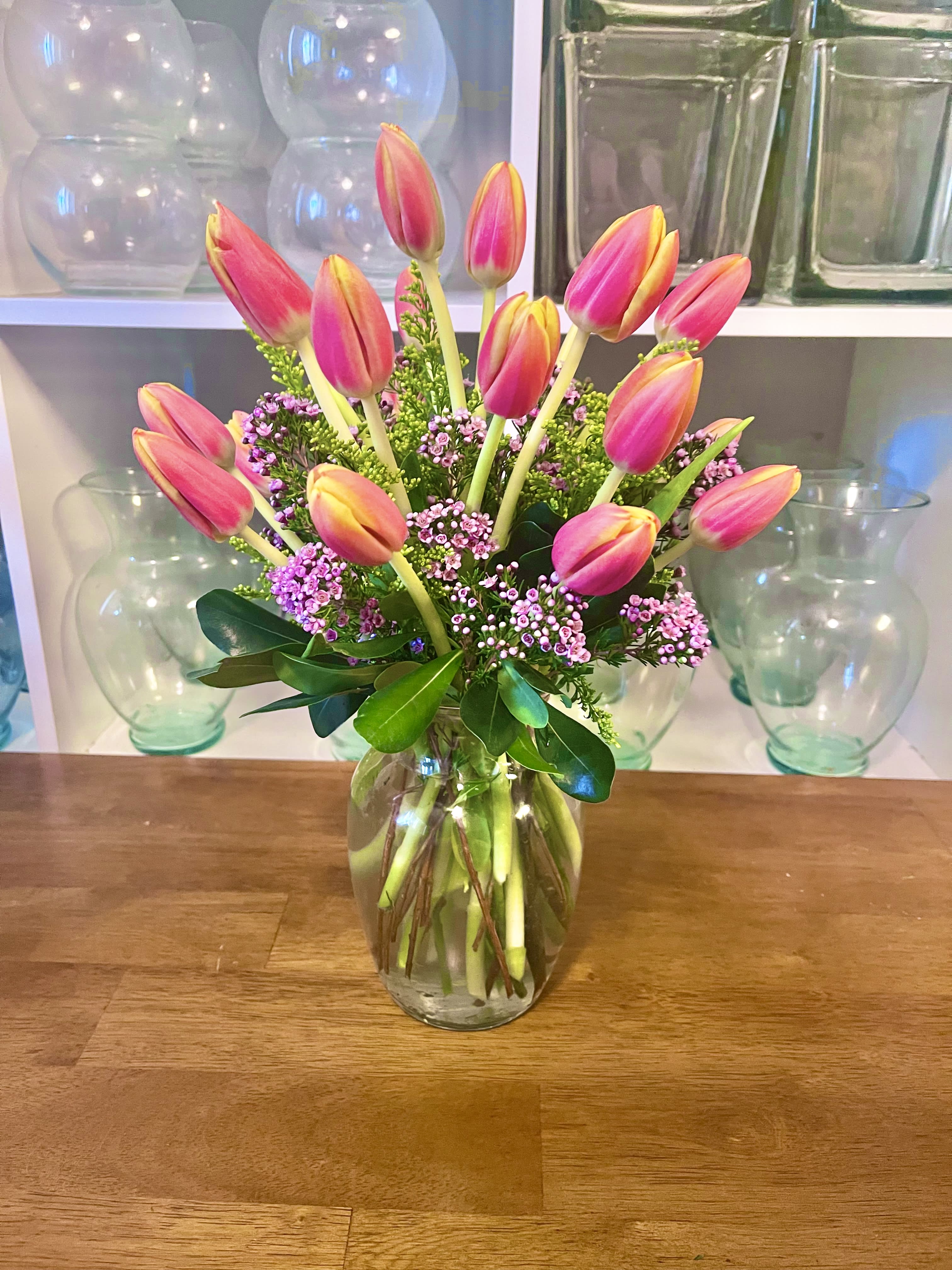 Orange Tulips - 20 stems of orange tulips with wax flower and greens in a clear vase. 