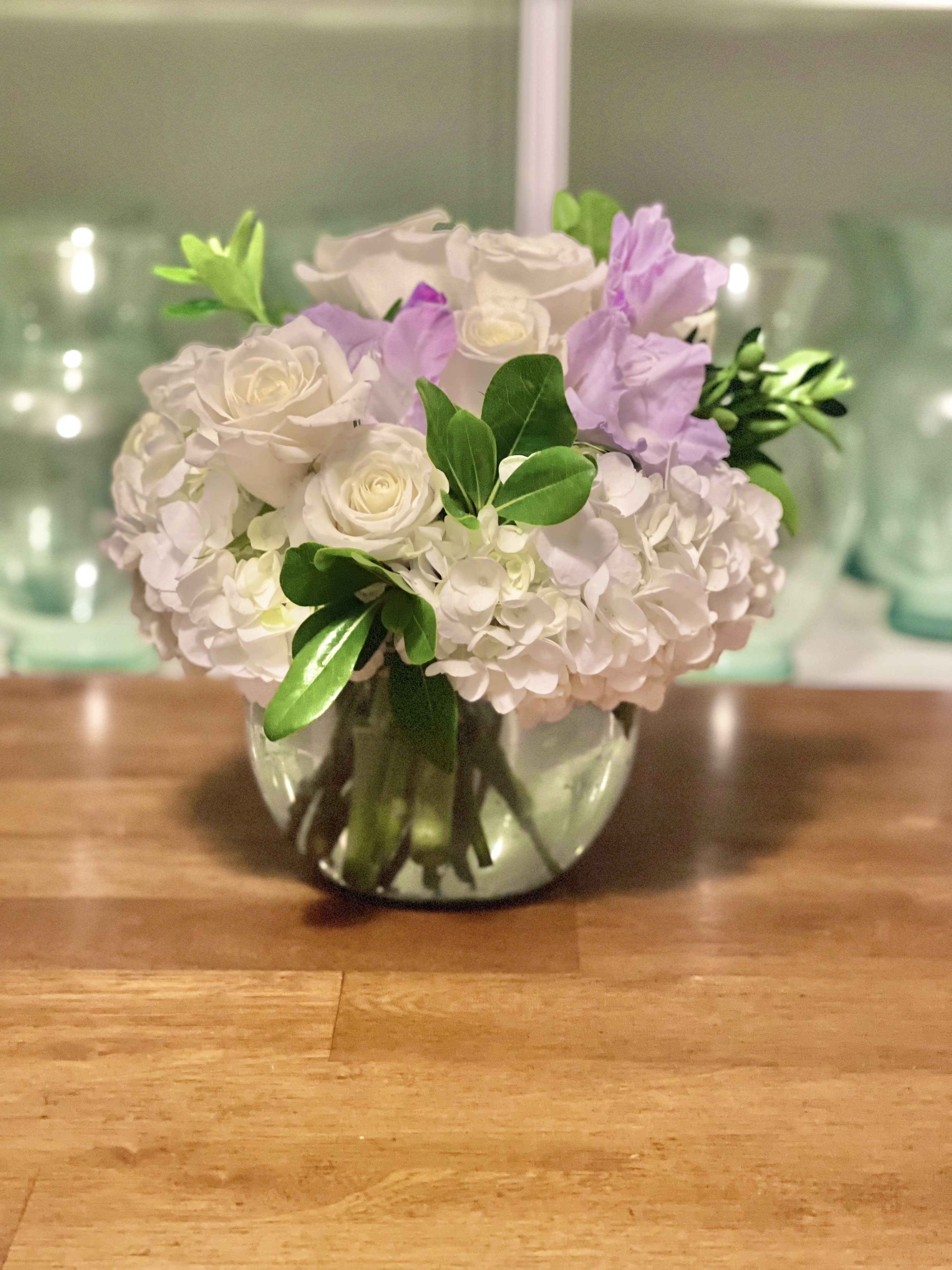 Peace - Beautiful white roses in a bed of fluffy white hydrangea and greenery with a light pop of color. 