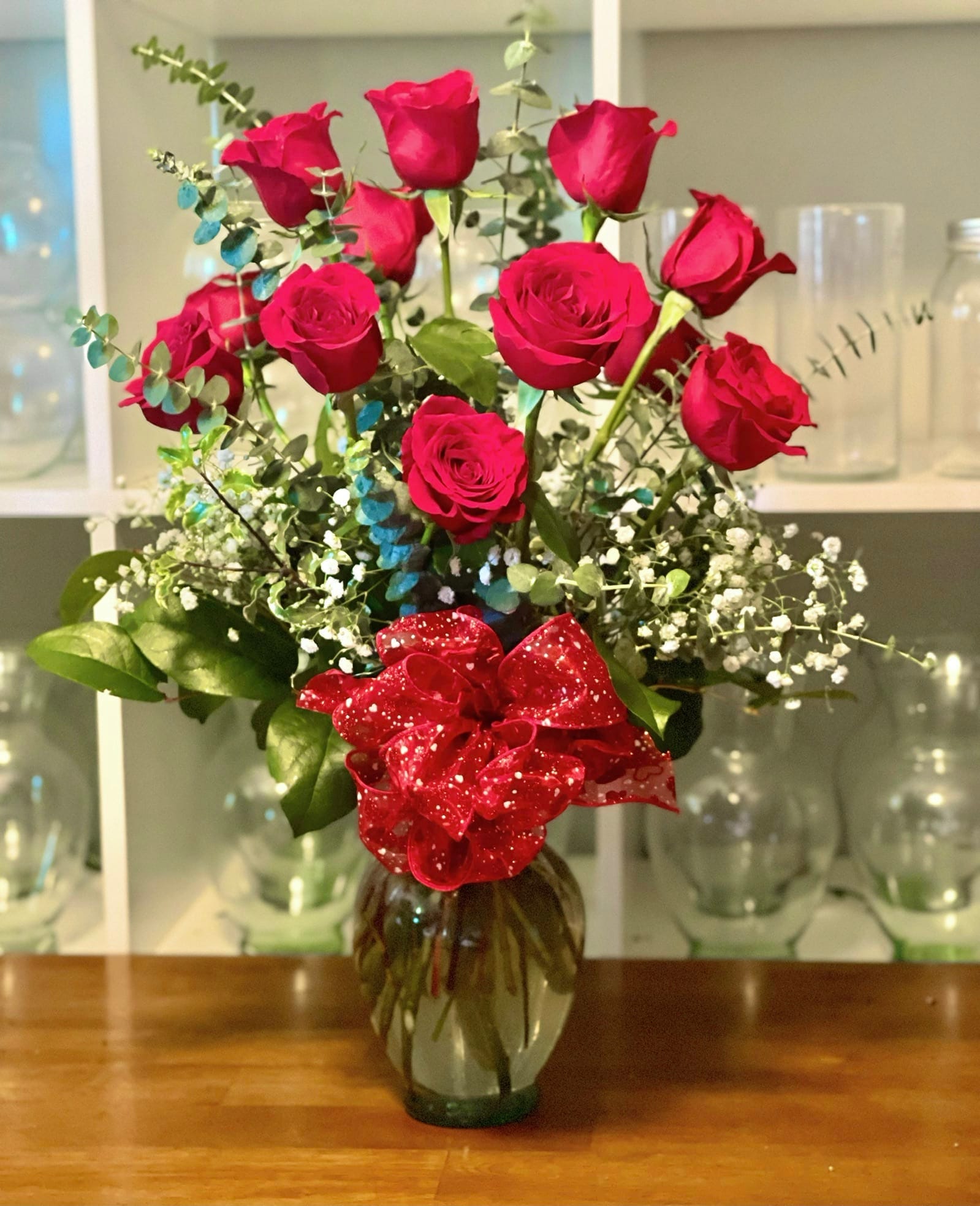 Bouquet of red roses in a glass vase with a red ribbon