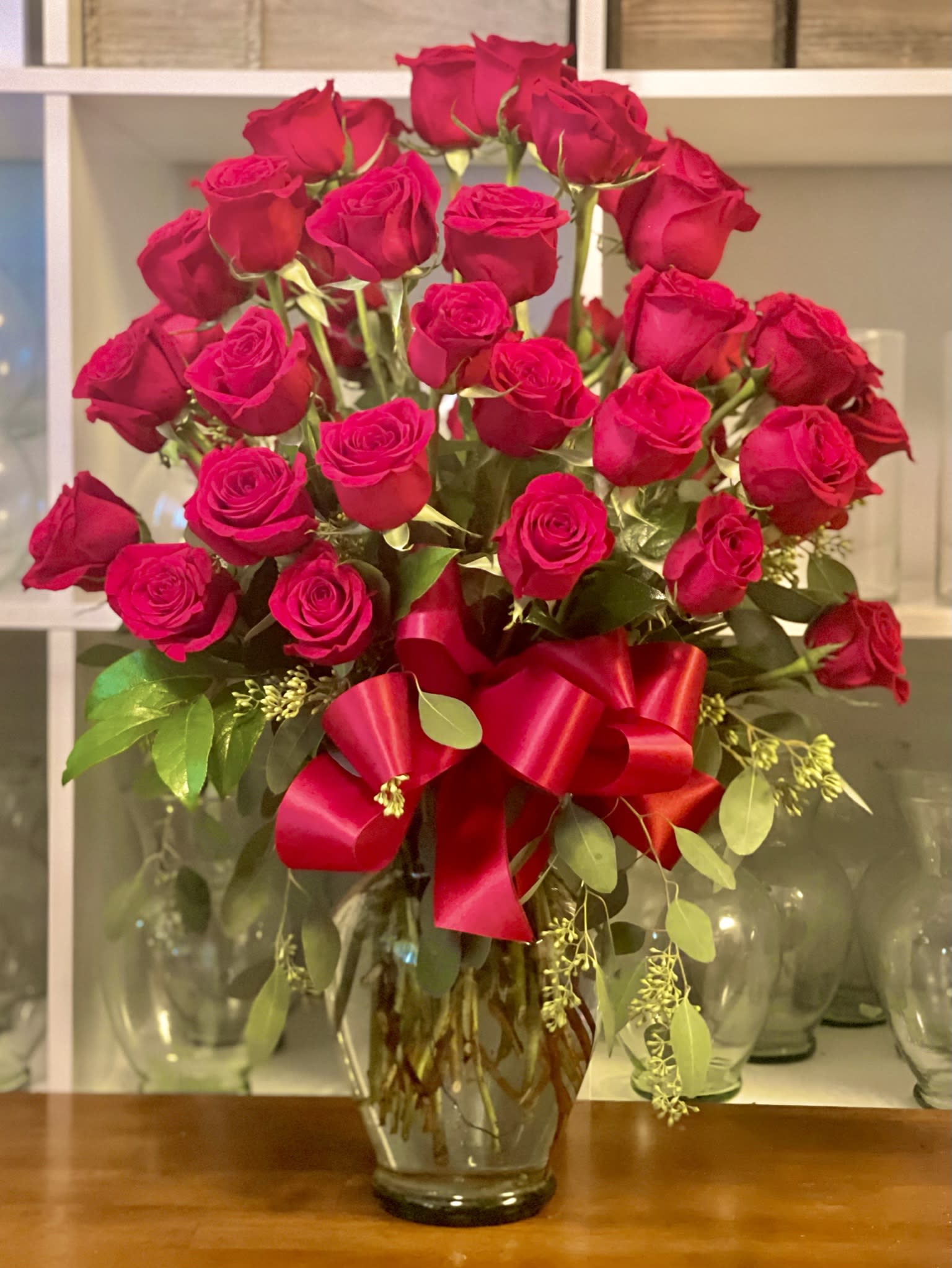 Bouquet of red roses in a glass vase with a red ribbon