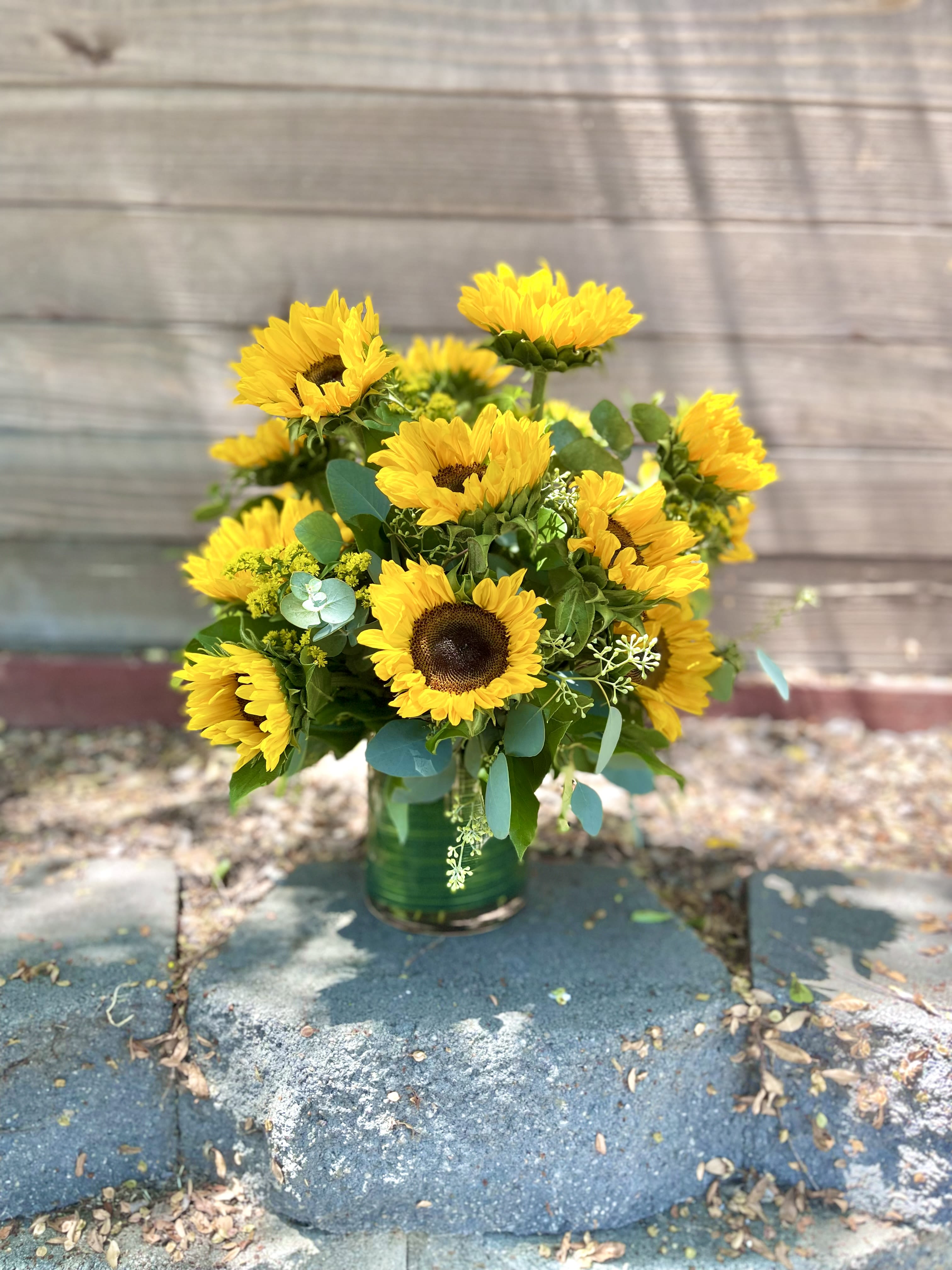 Bouquet of yellow sunflowers in a green vase