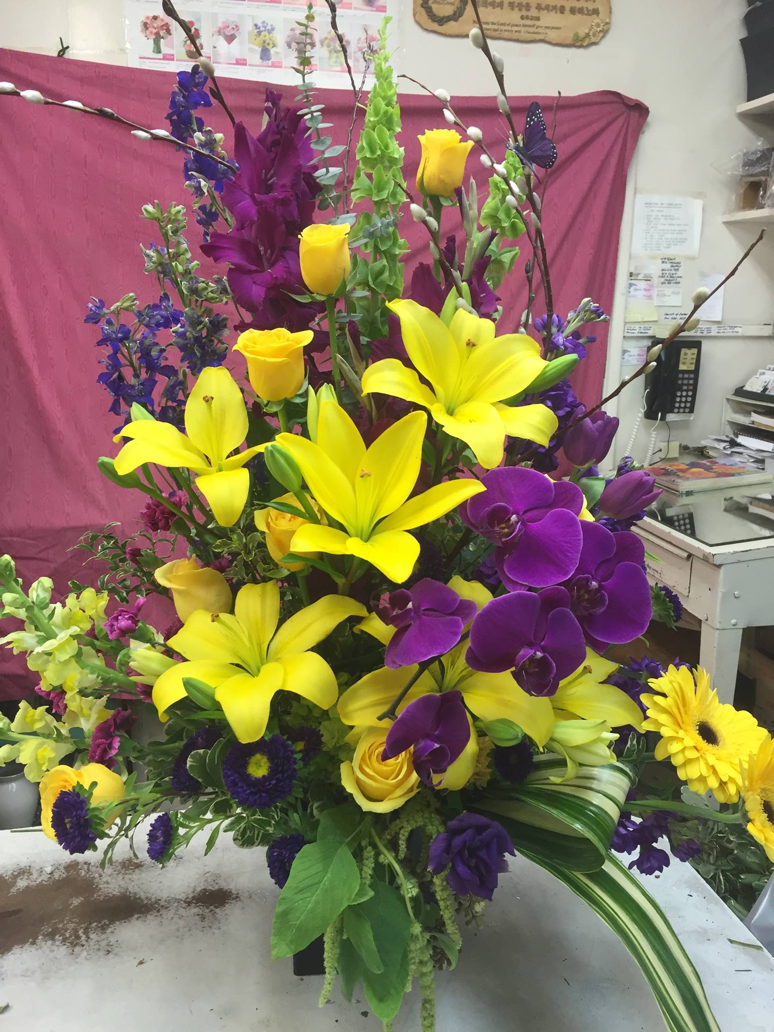 Tall bouquet with yellow lilies, purple orchids, and yellow roses