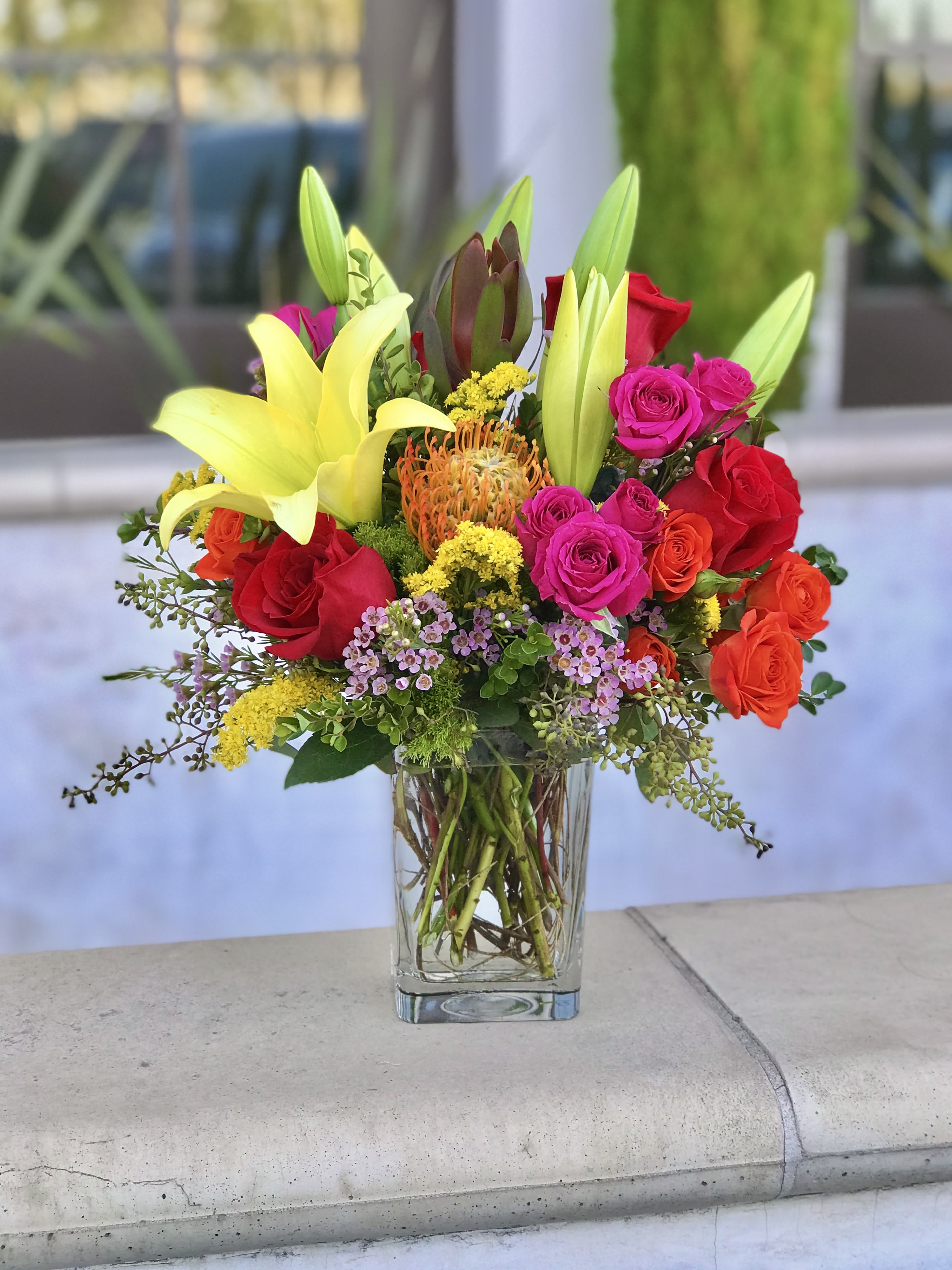Mixed bouquet of lilies and roses in a clear glass vase