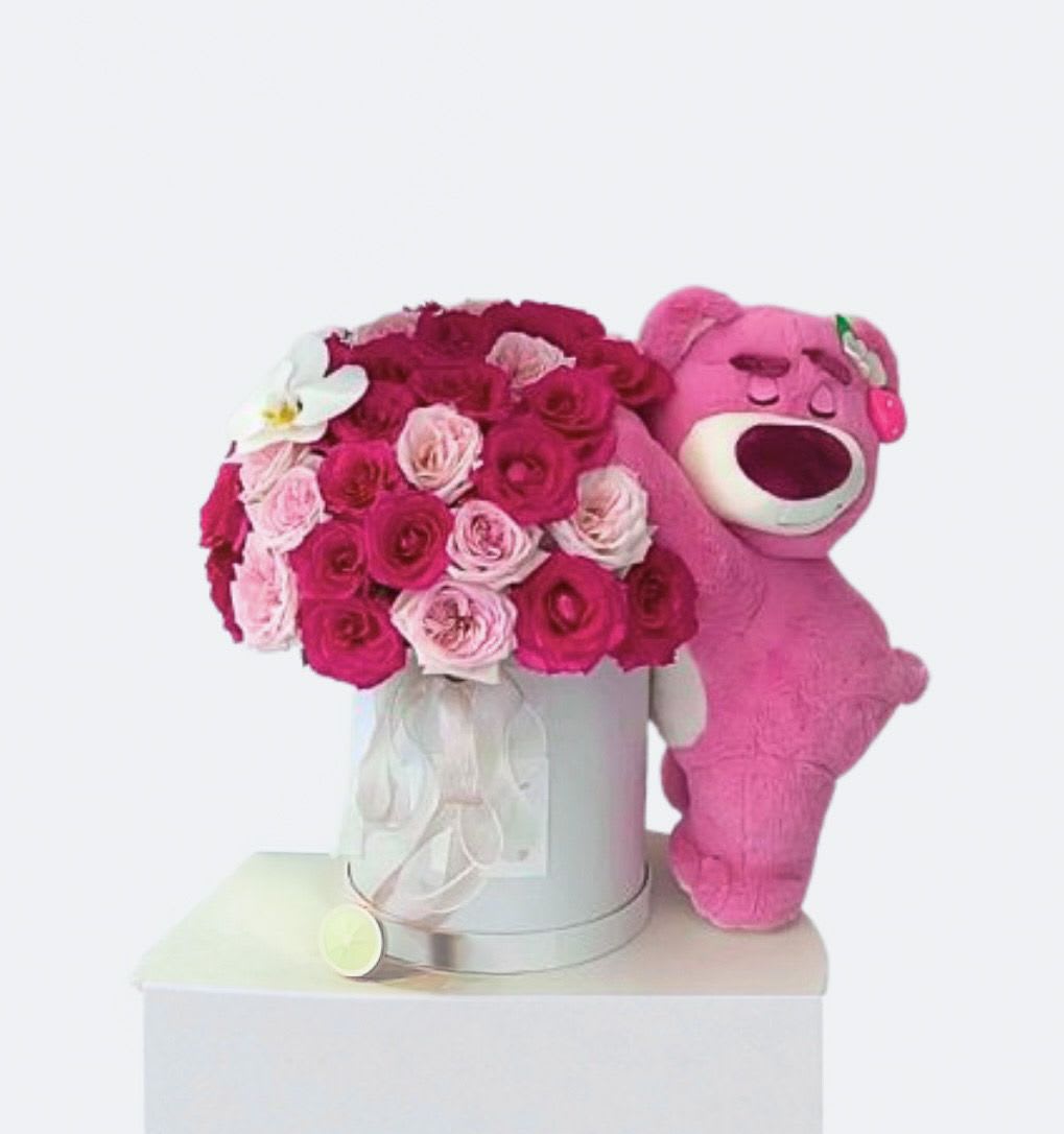 Pink rose bouquet in a silver box beside a pink teddy bear