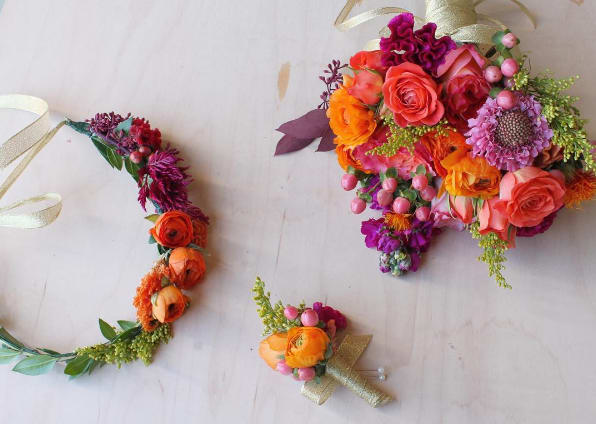 Colorful floral bouquet, wreath, and boutonniere on a light background