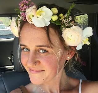 Woman wearing a floral crown with white and pale pink flowers