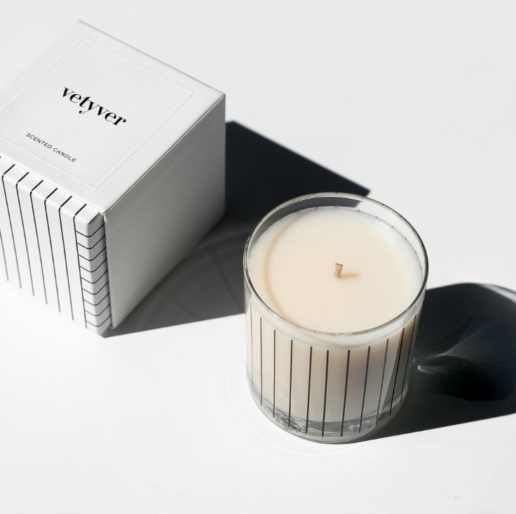 Scented candle in a glass jar beside its white box