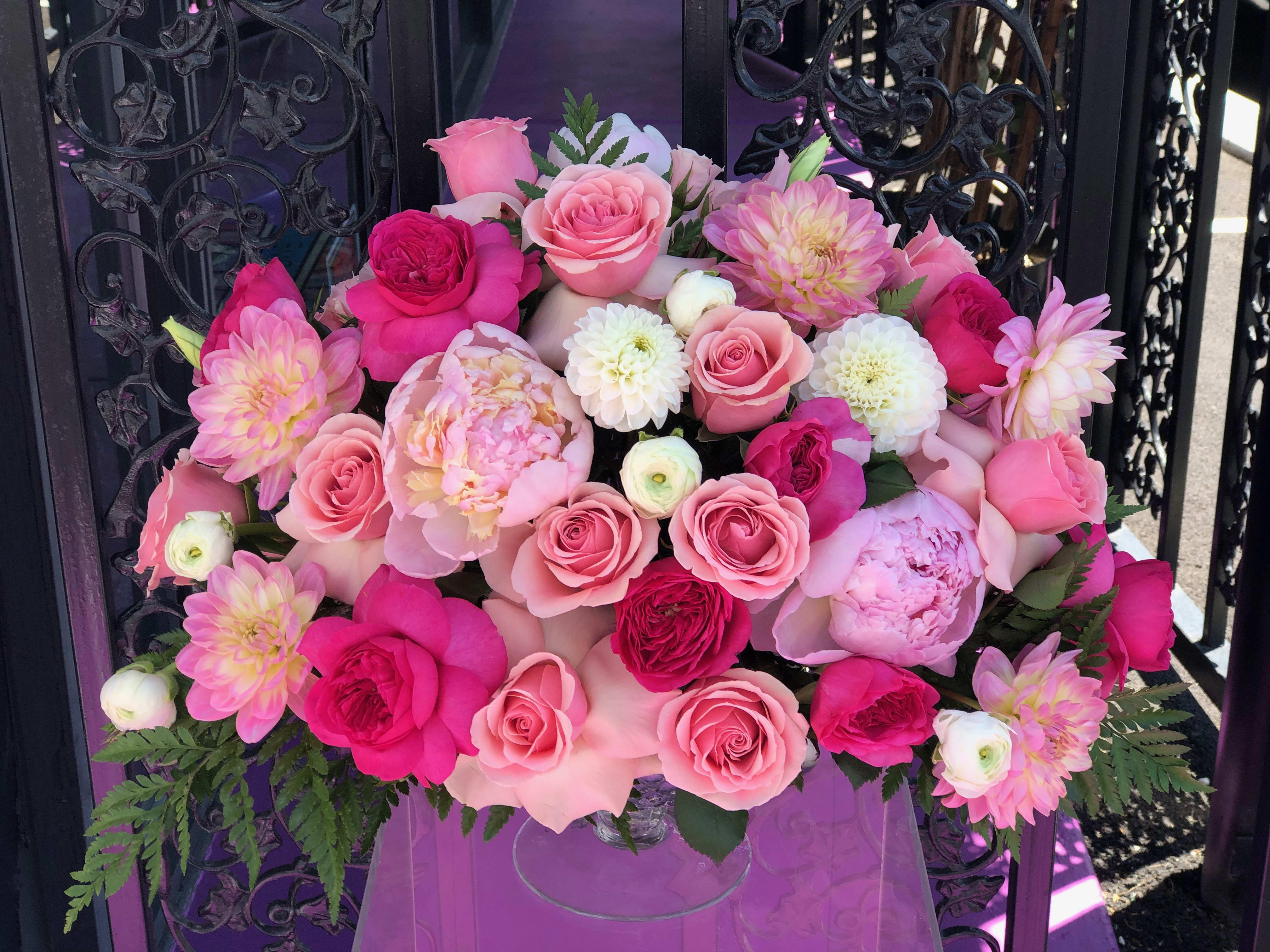 Pink and white rose bouquet with dahlia-like blooms in a clear vase
