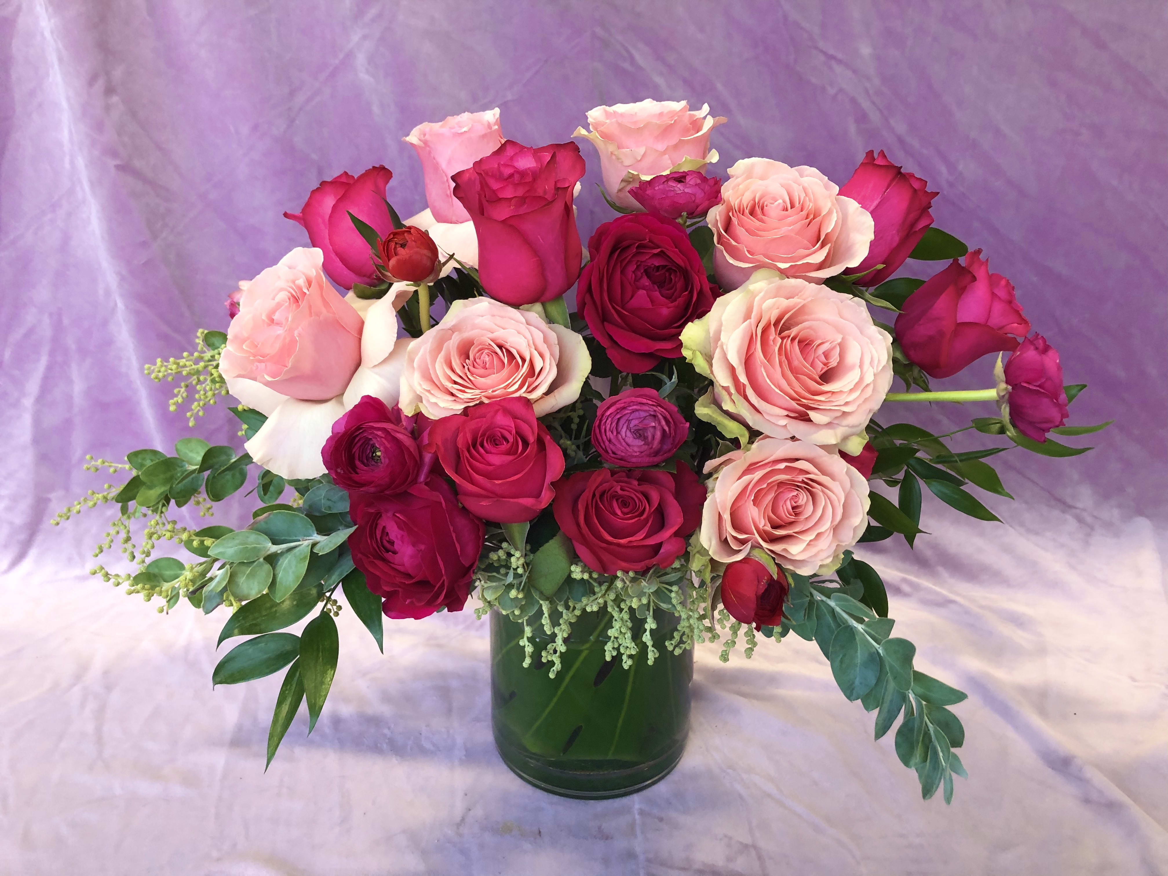 Pink and red roses arranged in a glass vase