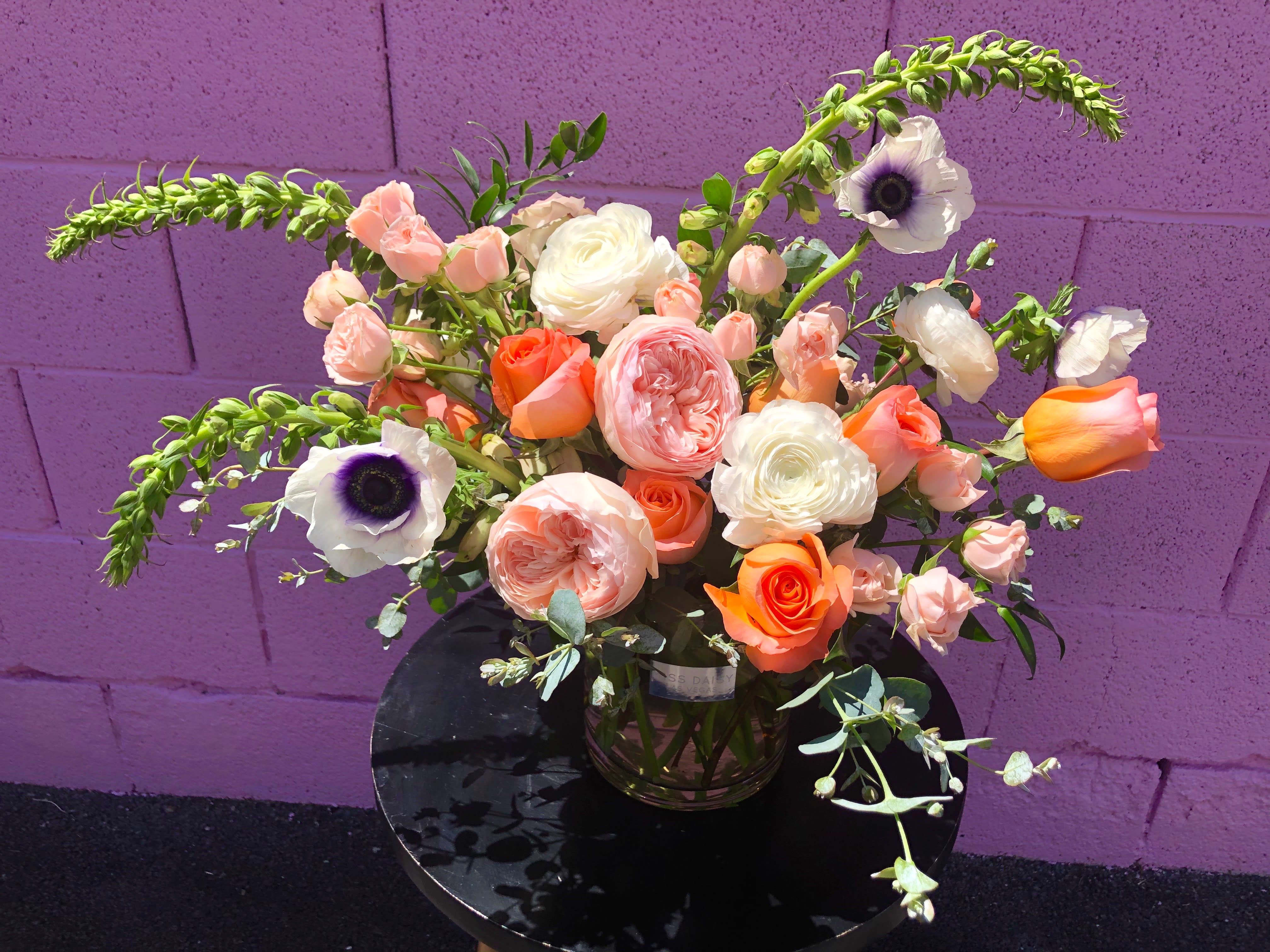Bouquet of peach, white, and orange flowers in a glass vase