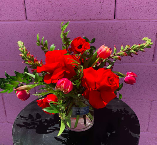Red roses and pink tulips in a clear glass vase