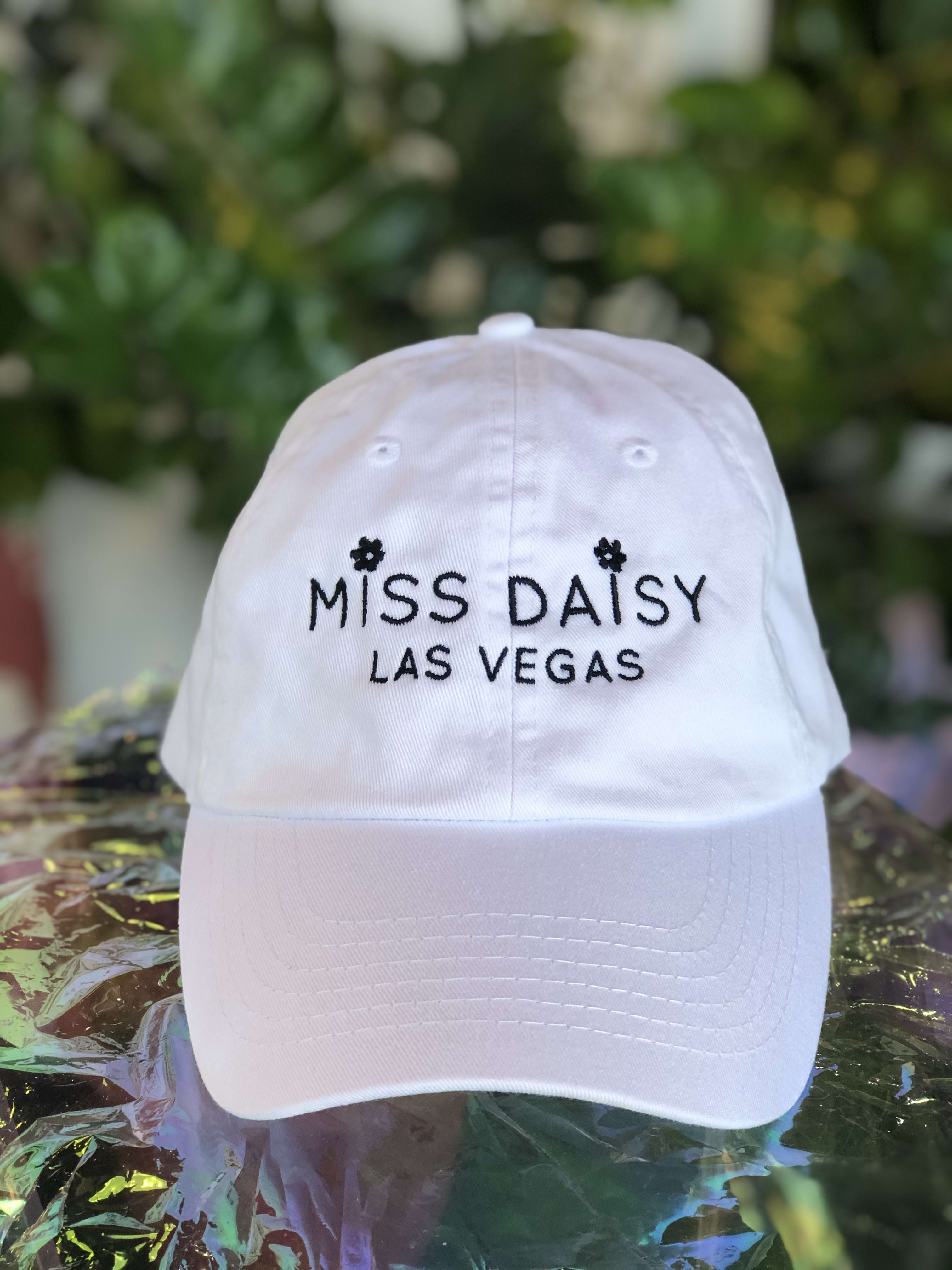 White baseball cap embroidered with "MISS DAISY LAS VEGAS"
