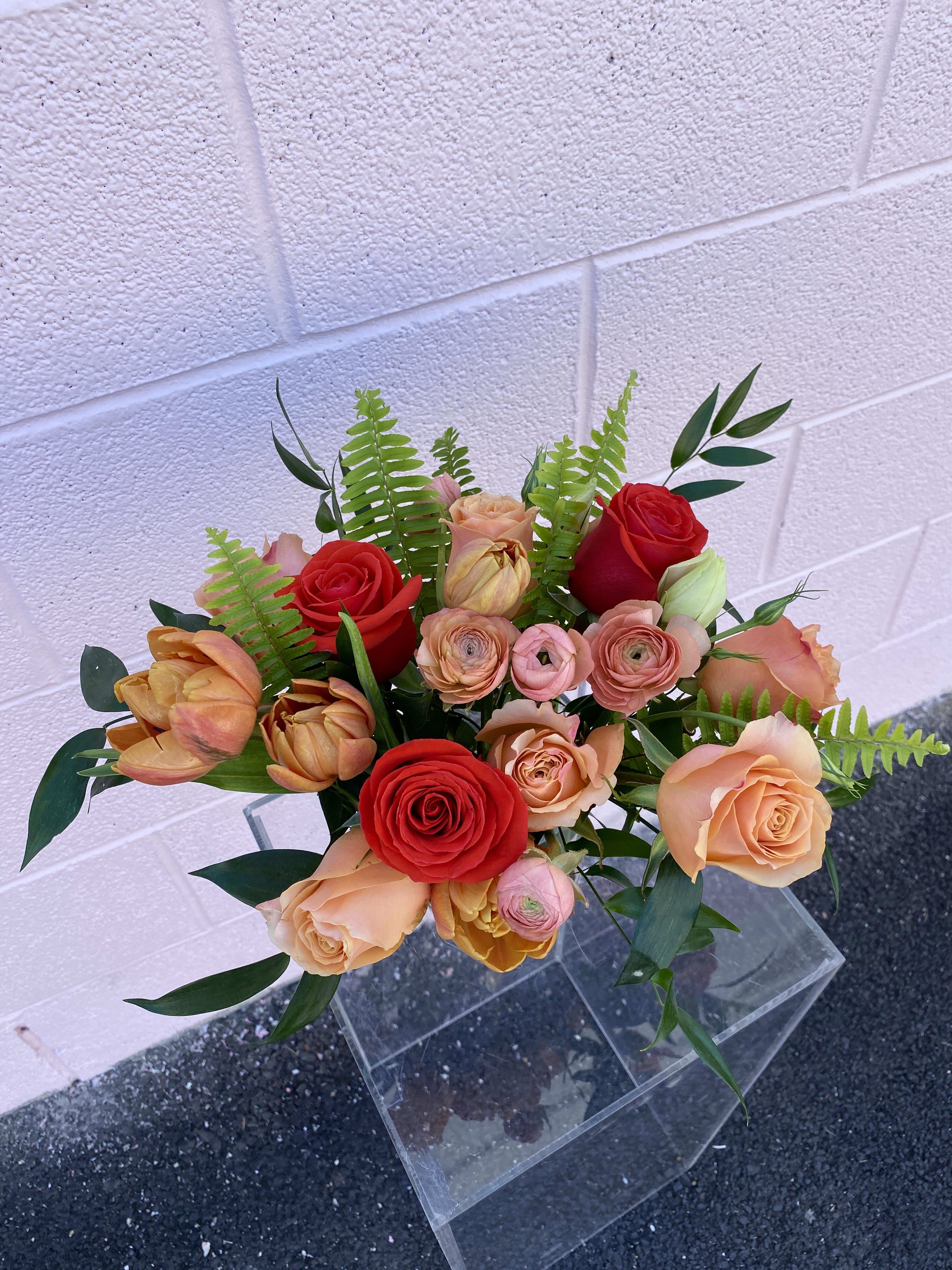 Bouquet of red and peach roses with fern foliage