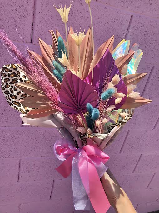 Sassy Committee Hand Wrap - This fun and funky hand wrap bouquet is filled with dried elements including bunny tails, palm spears, pampas grass and any other dried elements we have in stock on that day. This will bring sunshine and sparkle to anyones day! 