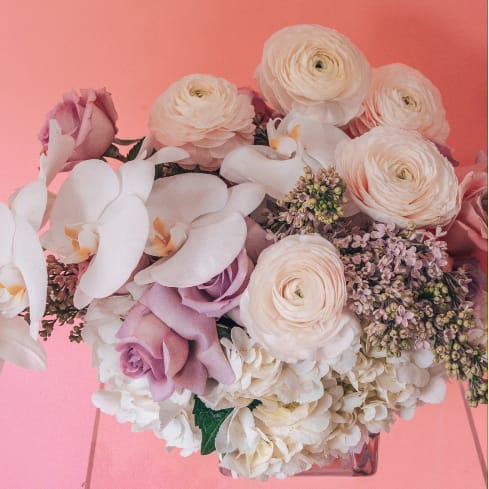 Bouquet of pale pink and white flowers in a clear vase