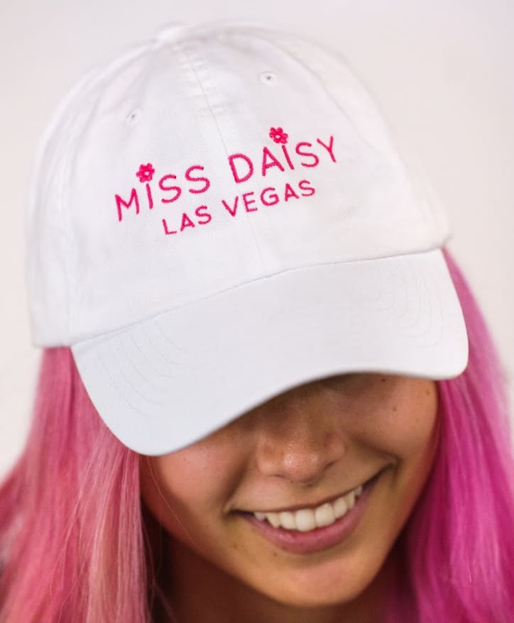 White cap with pink "Miss Daisy Las Vegas" embroidery