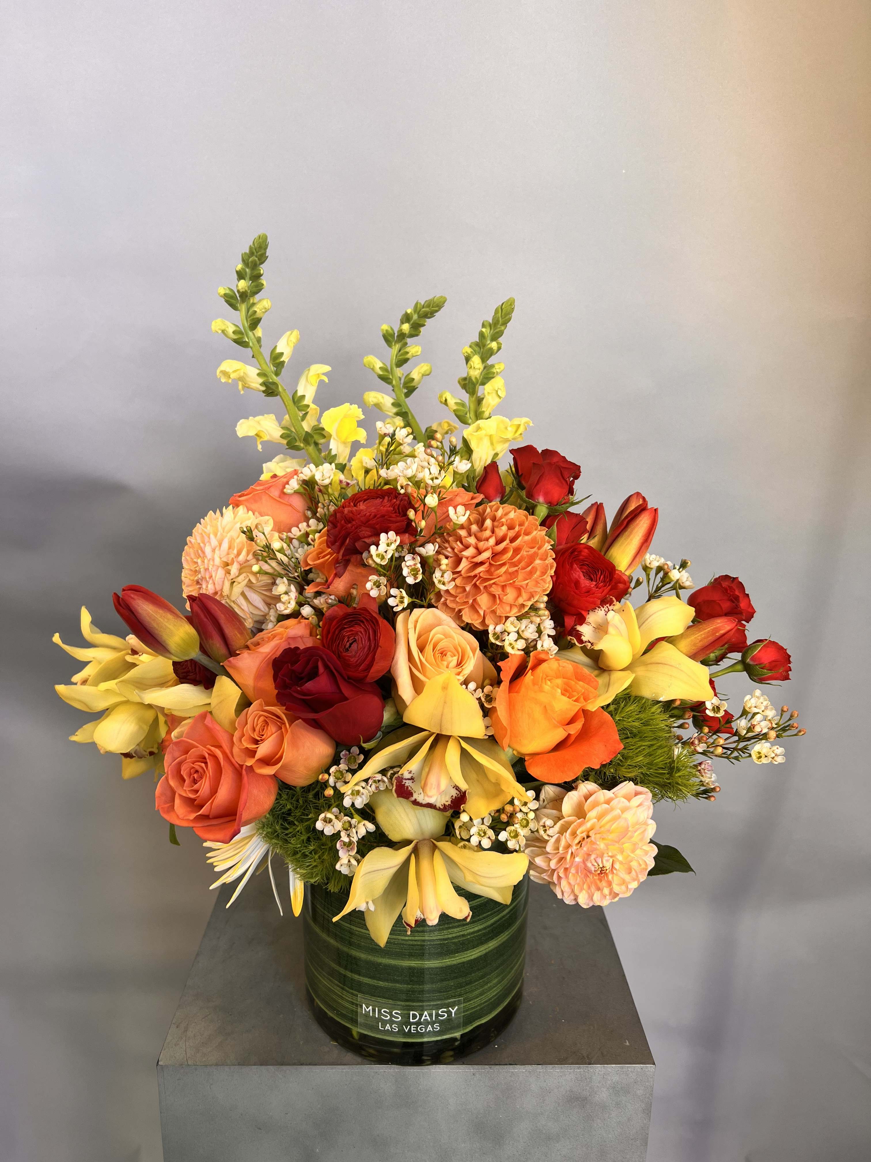 Year Of The Horse - The Lunar New Year is almost upon us, and 2026 is the Year Of The Horse! With its rich red, yellow, and orange tones this stunning design will bring the perfect touch of color to anyone's home.   You can feel the good luck this upcoming Lunar New Year with this arrangement, containing red roses, orange roses, yellow orchids, touches of snapdragons, and other beautifully toned blooms.