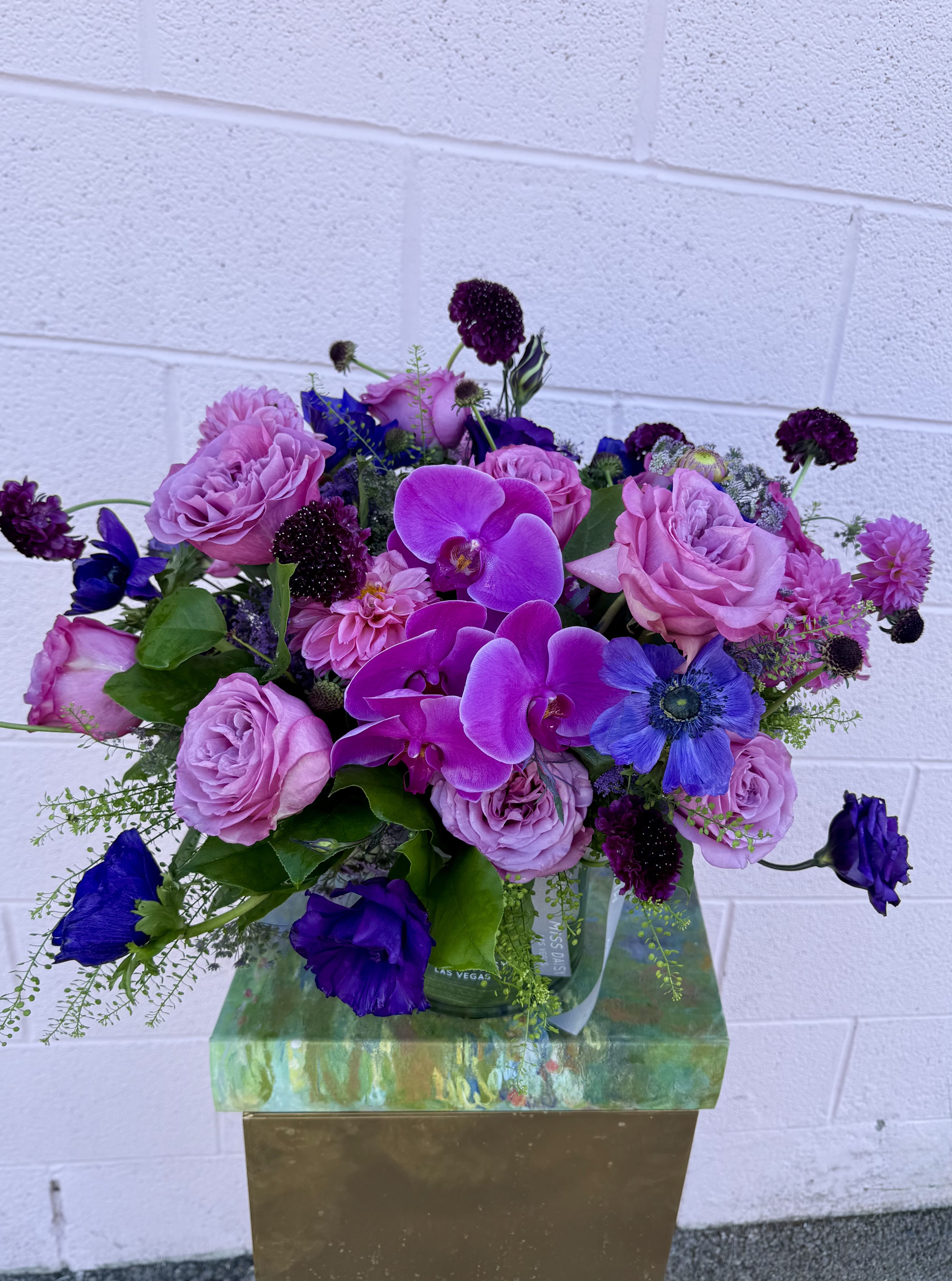 Bouquet of pink roses and purple orchids in a glass vase