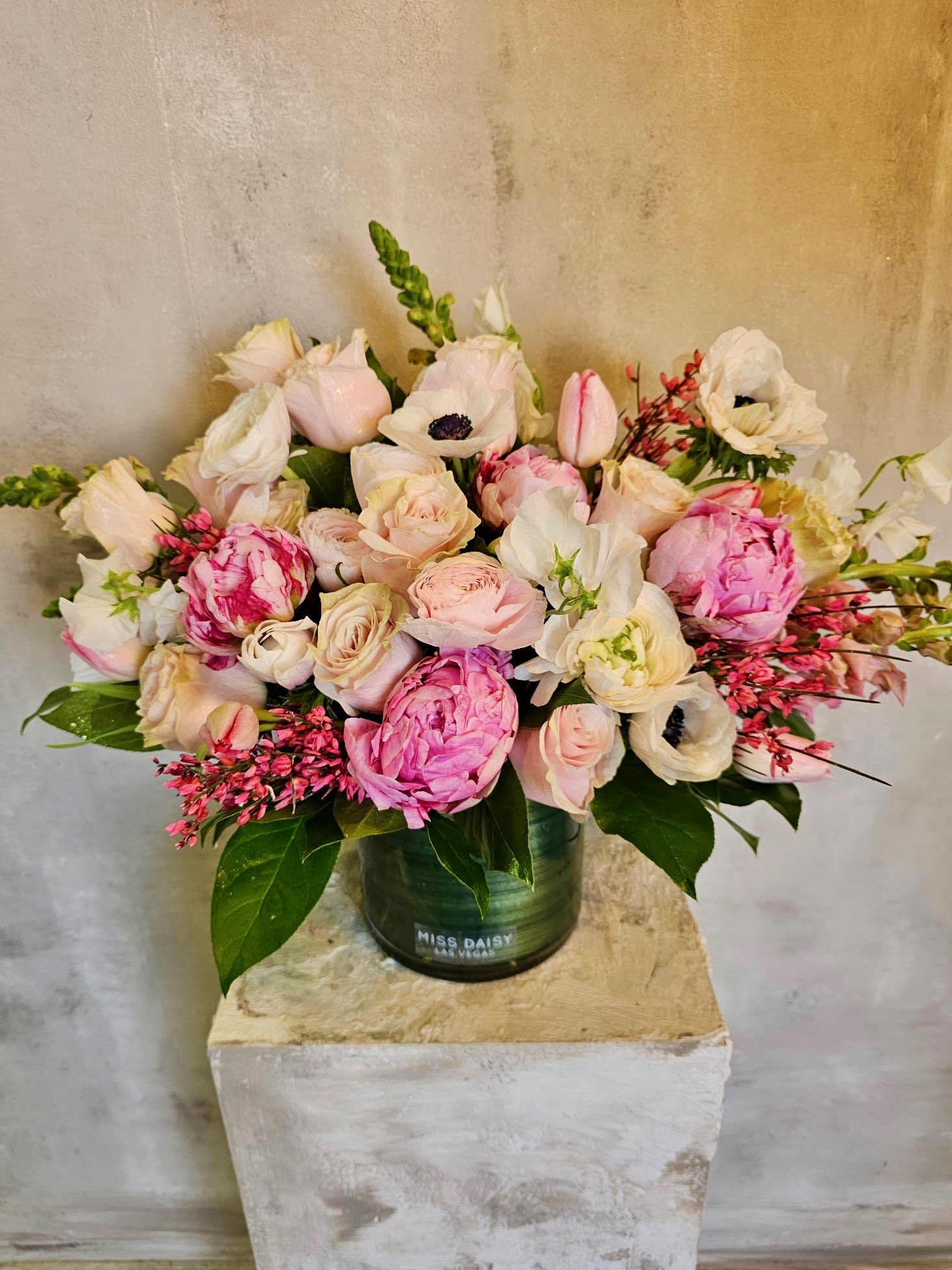 Pink and white flower arrangement in a green vase
