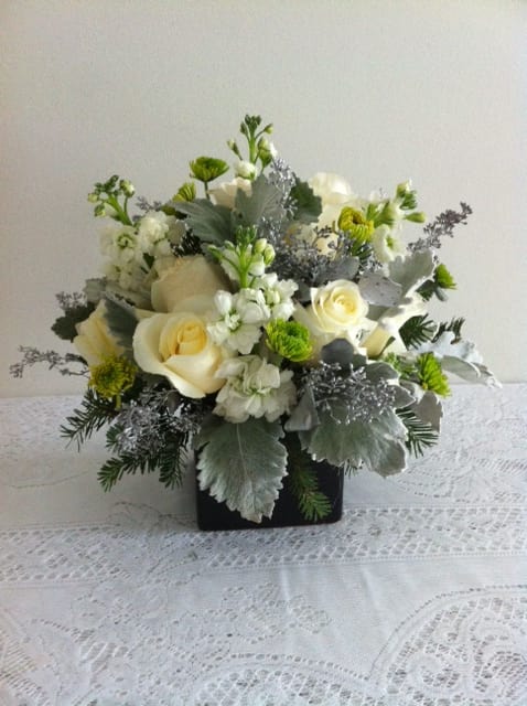 White roses and green-white flowers in a black square vase