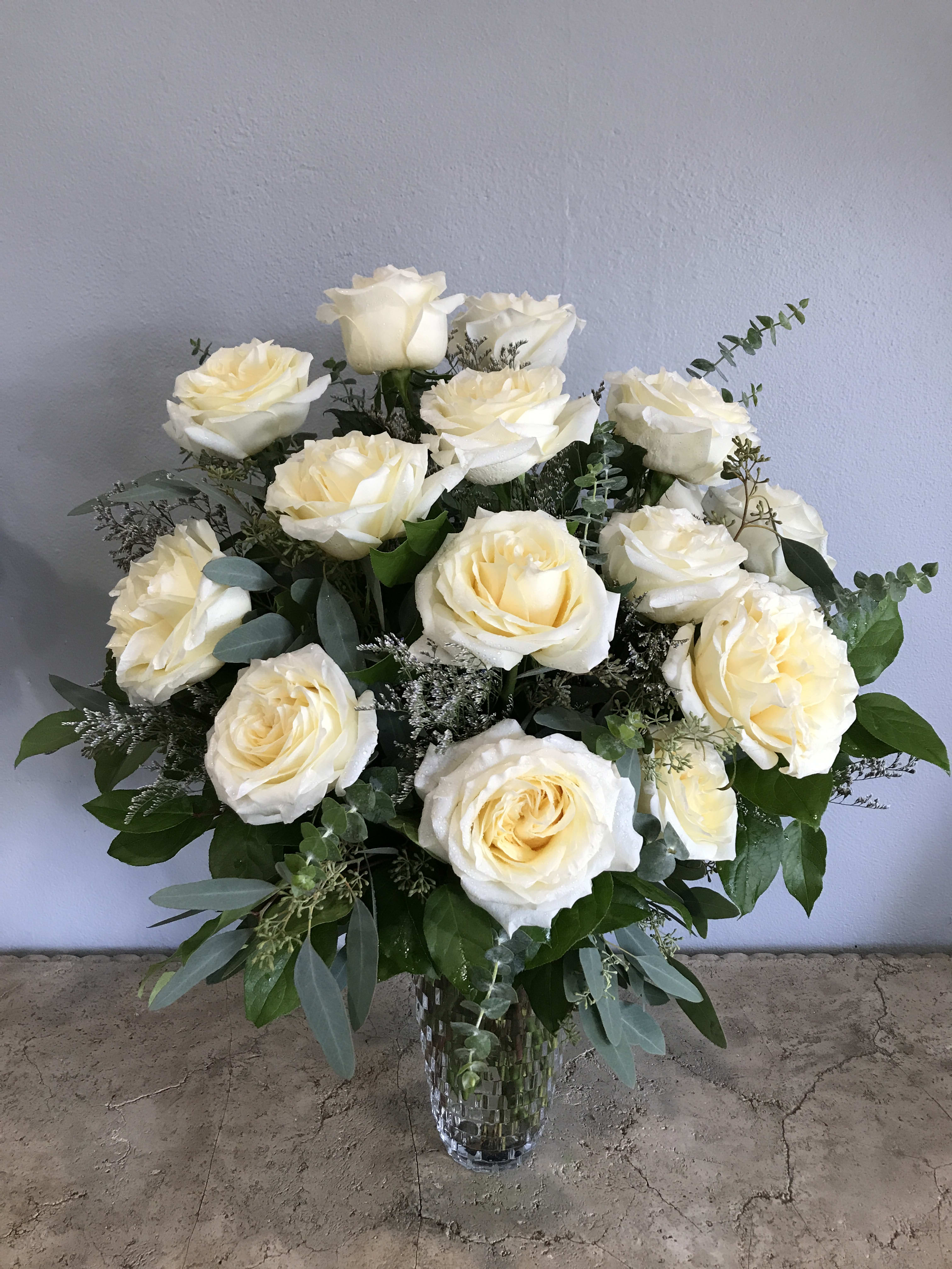Bouquet of cream white roses in a clear glass vase