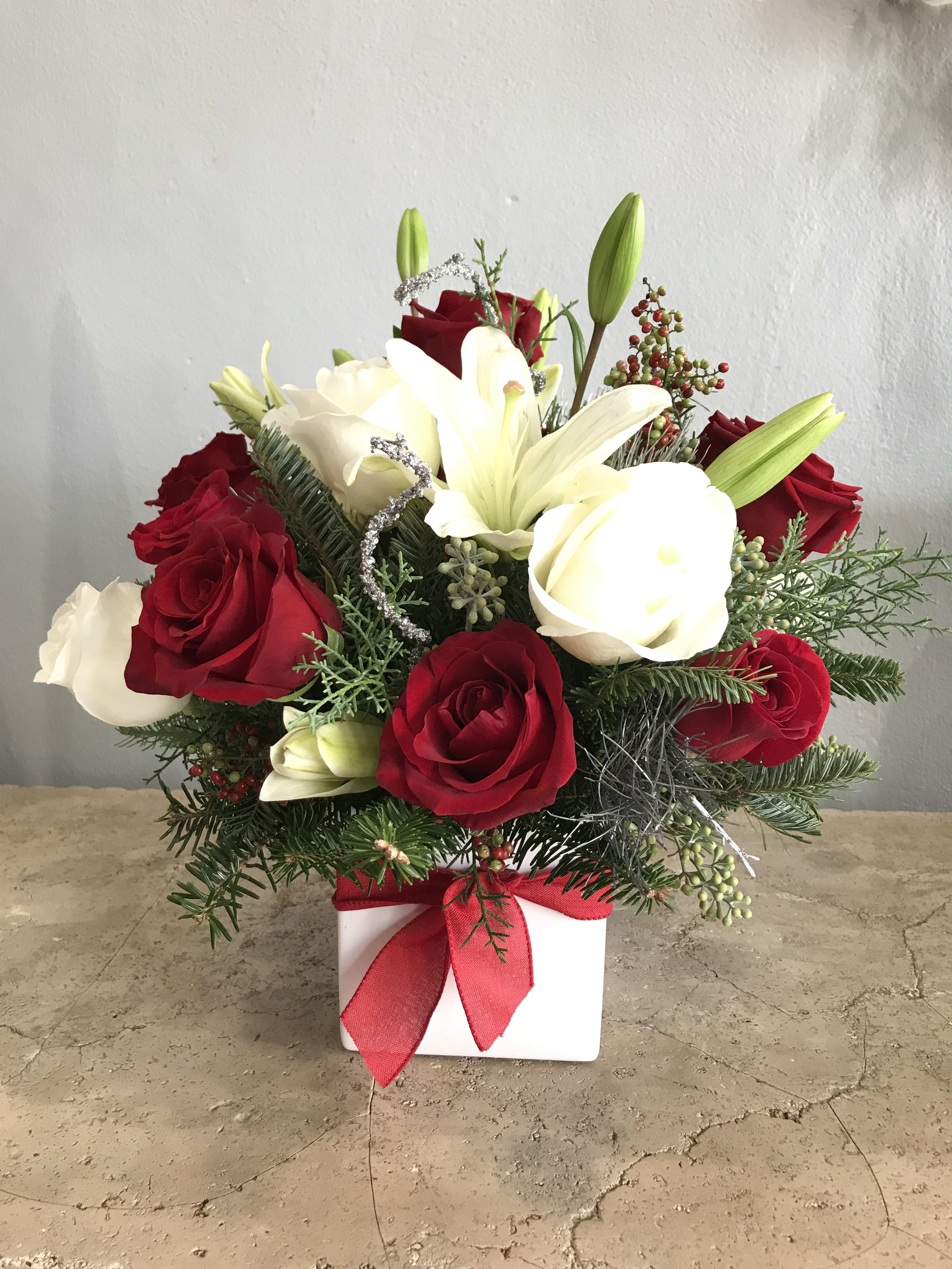 Red and white rose arrangement with lilies in a white box tied with a red ribbon