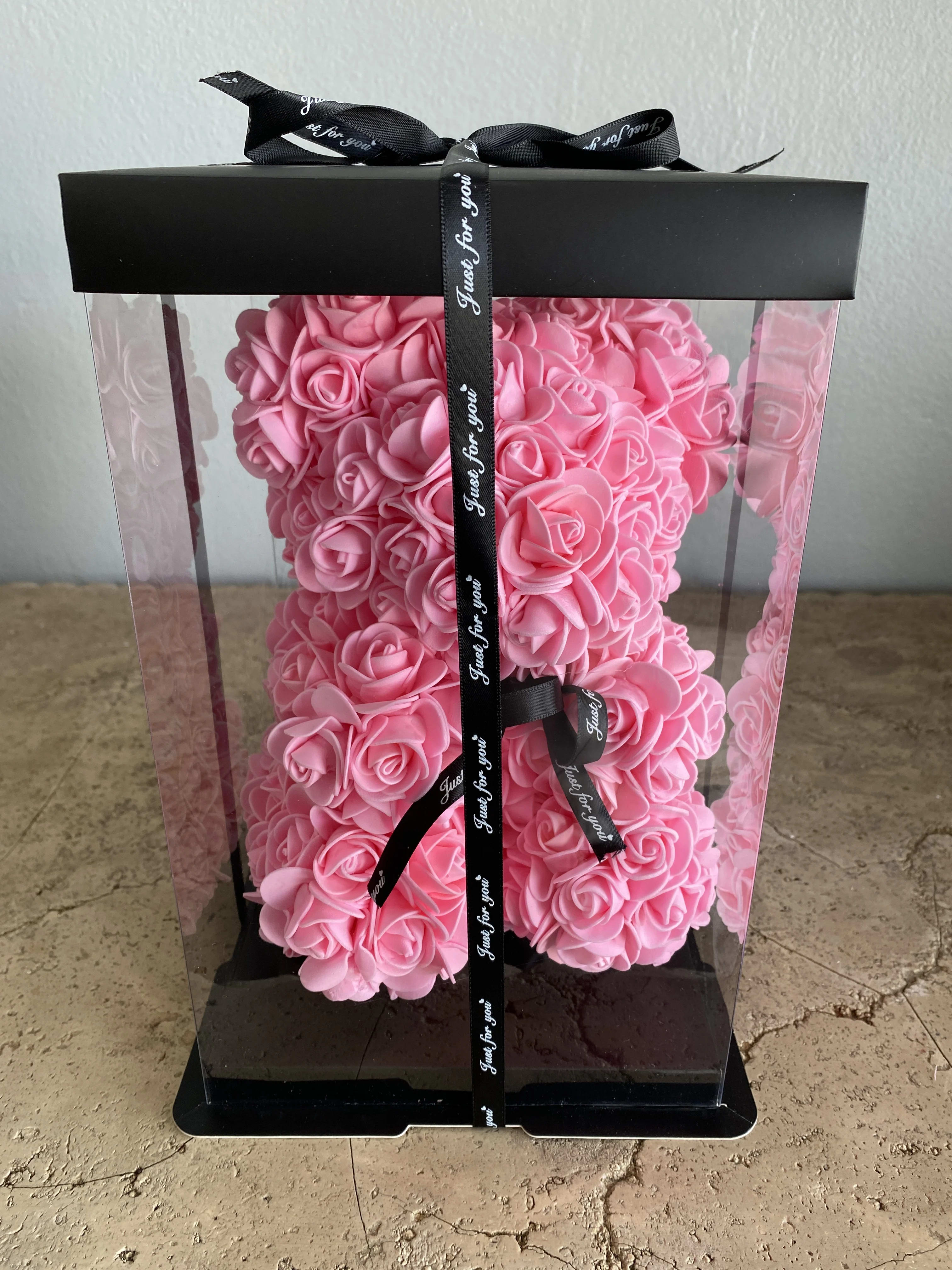 Pink rose-shaped arrangement in a clear gift box with a black ribbon