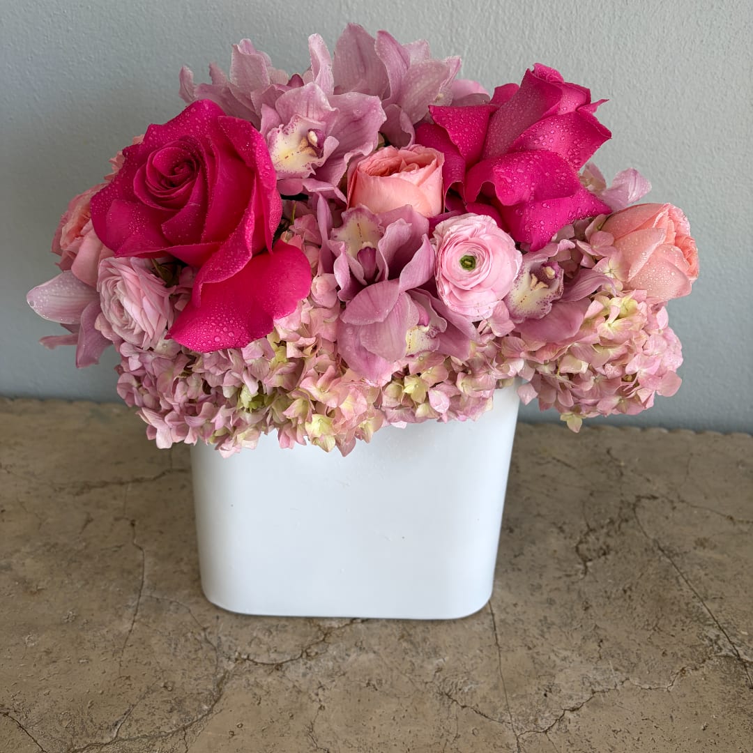 Pink and magenta flower arrangement in a white vase