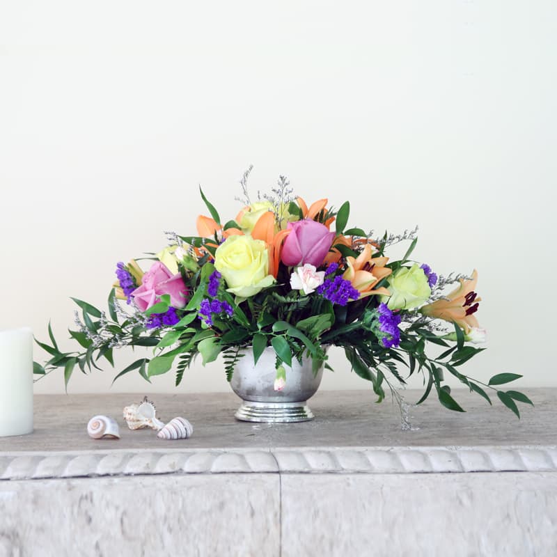 Mixed bouquet of roses and lilies in a silver vase