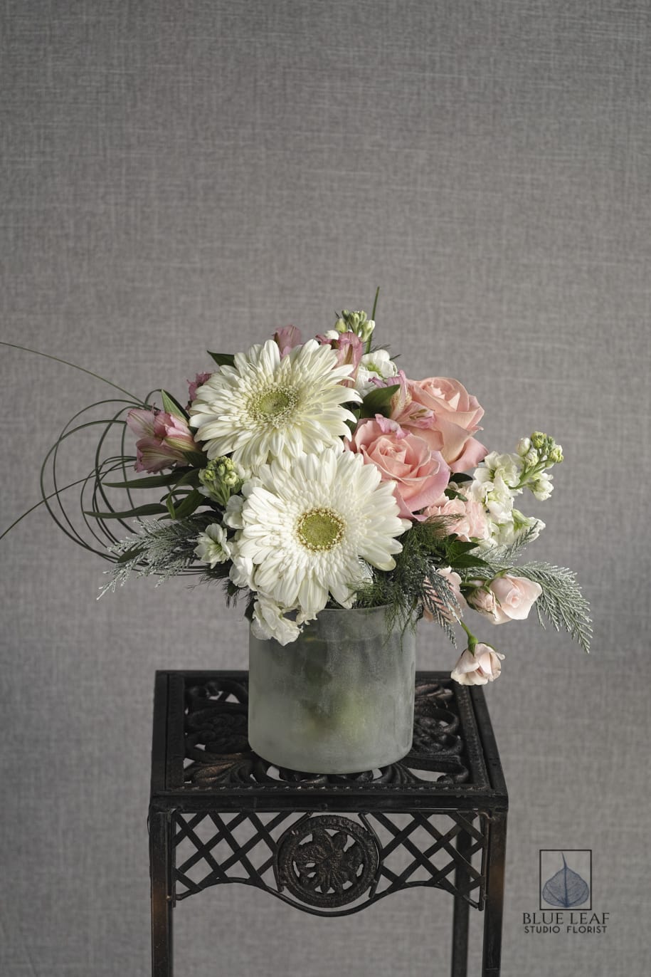 Pink roses and white daisies in a frosted vase