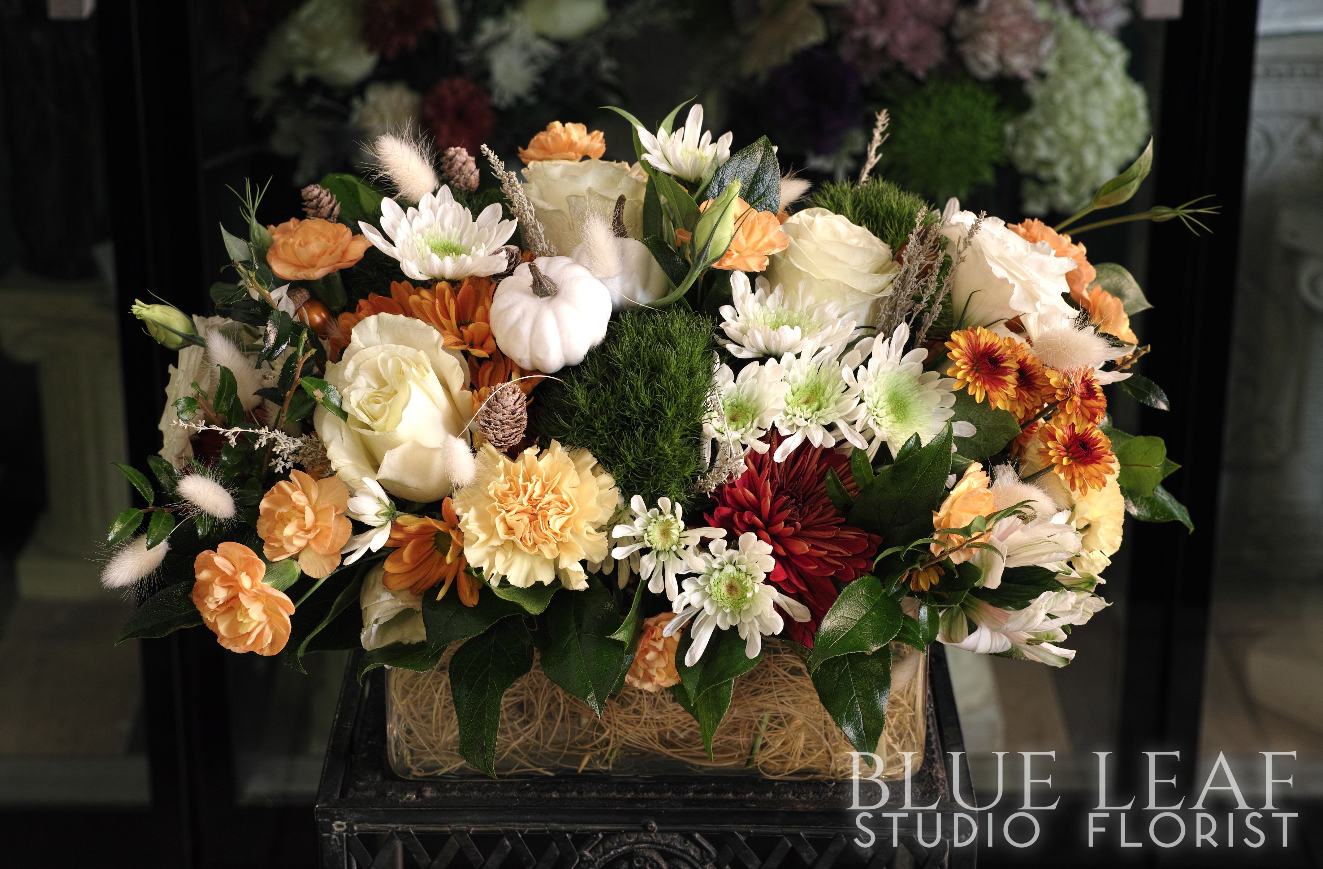 Autumn floral arrangement with white and orange blooms in a rectangular container