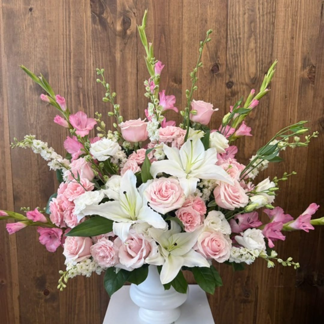 Pink roses and white lilies arranged in a white vase