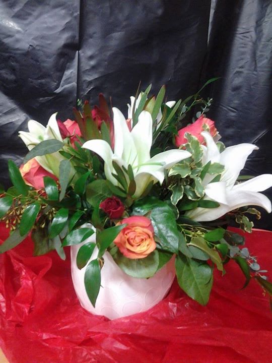 Lilies &amp; Roses  - White lilies, spray roses &amp; reg. roses with a mixture of greens in a white ceramic container.